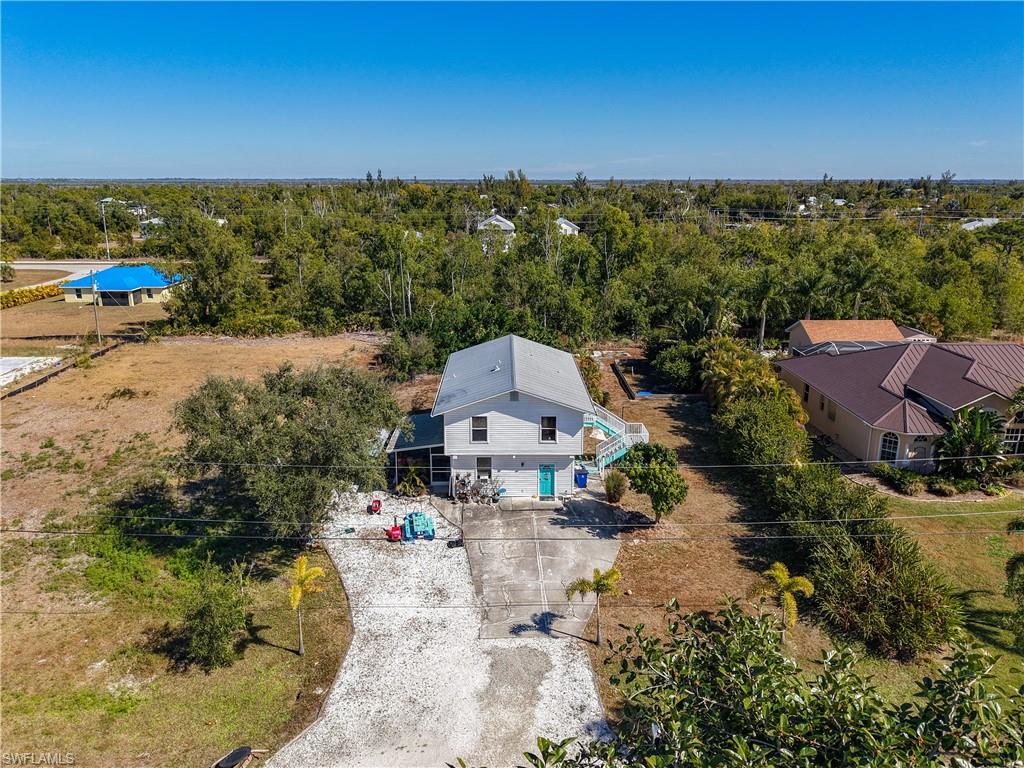 SHORT SALE. Located on a quiet street in the heart of Saint James City. Situated on Florida’s largest island—a true boater’s paradise—this home offers incredible peace of mind with a metal roof and a rare history of no flooding. The layout is unique and functional, featuring a private primary suite and a large living room on the first floor. Upstairs, the home opens up with a second family room, the kitchen, a dining area, and two guest bedrooms, all with natural light. With both interior and exterior stairs and a spacious side patio, this home is built for easy transitions and enjoying the coastal breeze. The outside of this property is just as impressive as the inside, featuring a massive yard with plenty of room to breathe. Whether you’ve been dreaming of building a pool, adding a large workshop, or just need a secure spot to park your boat and RV, this oversized lot can handle it all. It’s rare to find this much space on Pine Island with a home this large. If you are looking for a comfortable, worry-free home with room to grow and play, this is the one you’ve been waiting for.