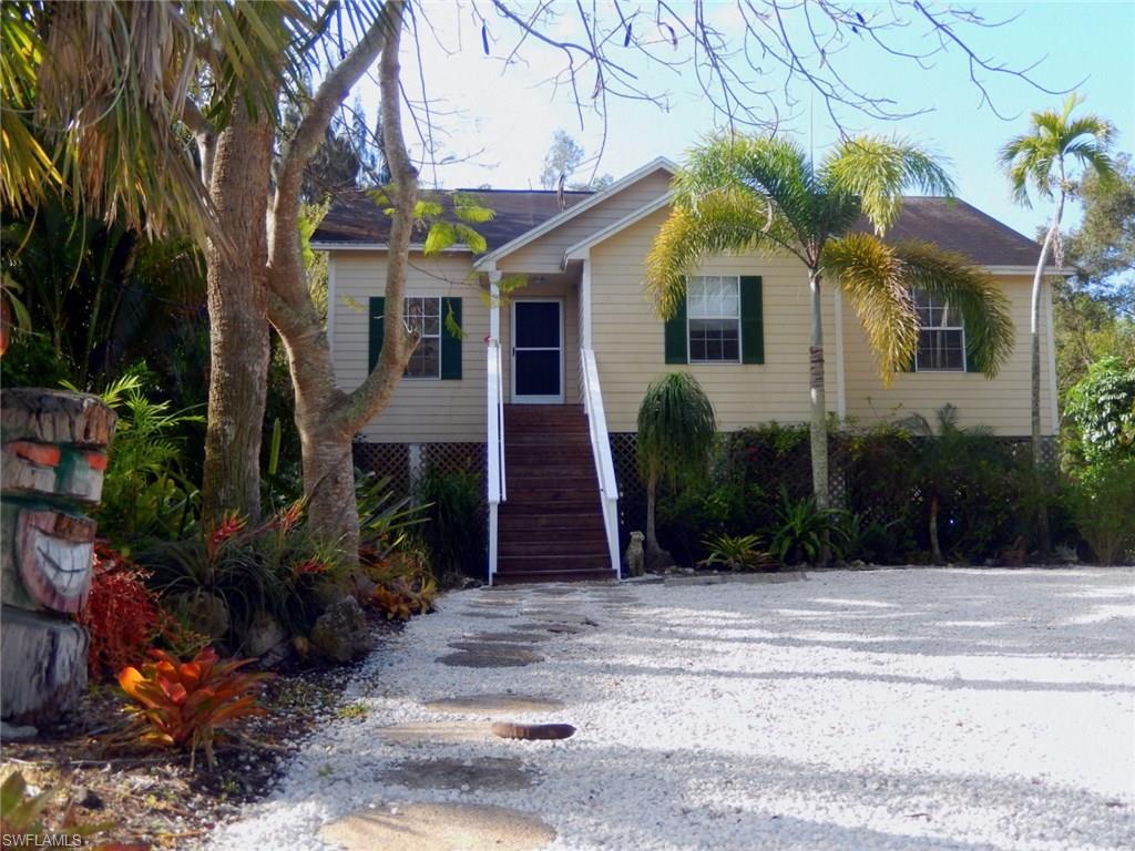 For those wanting a Natural Old Florida Tropical feel this little gem provides. Gardened with tropical plantings there is something to marvel in all seasons. Located off McGregor Blvd., south towards Sanibel Causeway, & close to Sanibel & Captiva Islands beyond. Easy access to grocery shopping &  Tanger Outlet stores. This Jim Walters concrete block piling elevated frame construction ranch was  built in 2003 & offers a volume ceiling in the great room that opens to the eat in kitchen, 3 bedrooms & 2 full baths, new carpet & new kitchen flooring, inside utility, & an open deck out back to enjoy a lush private view on almost 1/2 acre lot. ...& no HOA fees.
Underneath provides a huge open area to park cars, boats, ski-dos & all the equipment you desire. There is also a built in storage room below, perfect to lock up tools.   On central sewer, the house comes equipped with an RO water system, newer water softener & a recently serviced & cleaned tank & aerator. The 16 seer a/c system has a 5 year warranty remaining.  For your pet, a fenced in area contains out back. 
If you drive the  neighborhood a variety of large homes will surprise. This quiet little neighborhood is a unique find.