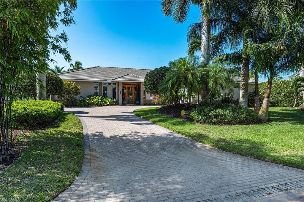 Rare find west of Crayton Road with southern exposure on a quiet street in the heart of the Moorings with a 2019 cement tile roof. This architectural-influenced home features an open floor plan with soaring ceilings and banks of architectural windows, creating naturally lit tropical views from every room. The kitchen is appointed with Danish mahogany cabinets and complemented with stainless steel Thermador and Sub-Zero appliances. Outstanding stainless steel hood over a six-burner Russell range gas cooktop. All this offers a dream chef's kitchen. French limestone floors extend throughout the home, including the lanai. The thoughtful first-floor master suite is enhanced with maple flooring and a coffee bar, which allows the morning coffee-in-bed lifestyle. The home presents lush landscaping on a palm-lined preferred street, just five blocks from the Gulf beaches. You will know you are at home when you arrive at this designer masterpiece. Residents will appreciate breathtaking sunsets with access to the Moorings Private Beach just a few minutes away.