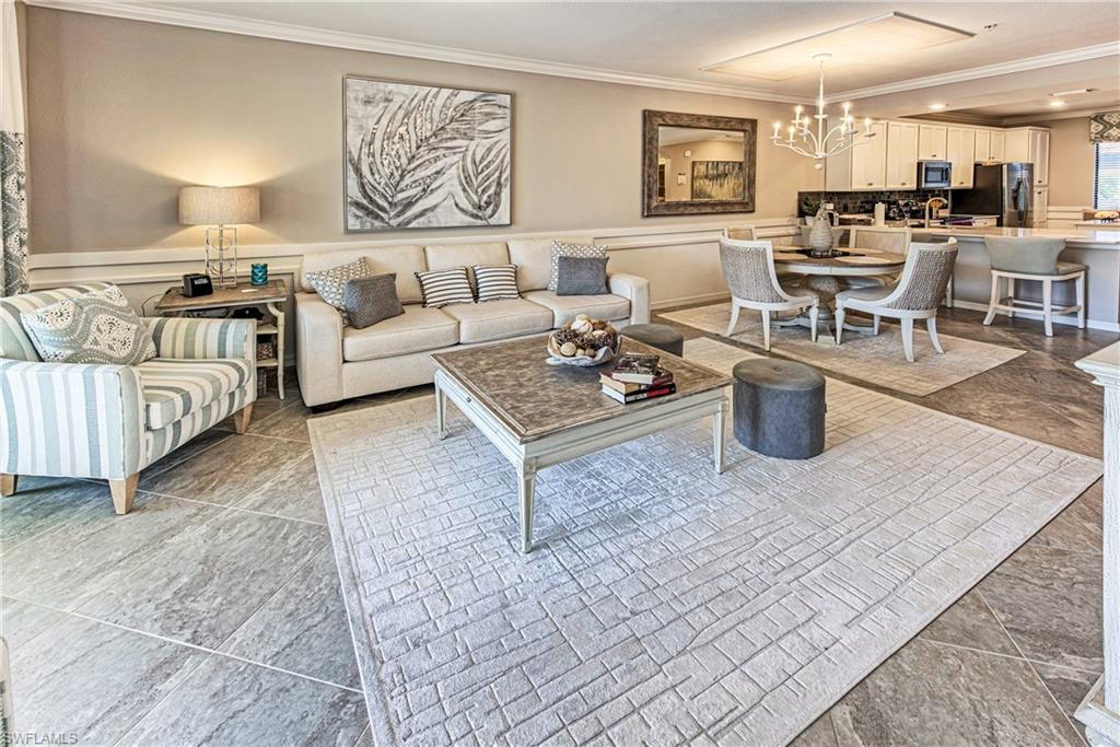 New to the market! Beautifully appointed former developer model, this turnkey furnished first-floor Arbor floor plan offers an exceptional opportunity to enjoy the coveted resort lifestyle of Treviso Bay. Featuring 2 bedrooms, 2 bathrooms, 1,194 square feet of thoughtfully designed living space, a covered carport, and a screened lanai overlooking a tranquil lake and preserve view. This residence is ideal as a primary home, seasonal retreat, or investment property. Designed with a light coastal aesthetic, the interior showcases numerous upgrades including tile flooring throughout the main living areas, elegant wainscoting, designer lighting and fixtures, decorative finishes, a stylish kitchen backsplash, upgraded paint, brushed nickel hardware, and tasteful designer décor. The open-concept floor plan seamlessly connects the kitchen, dining, and living areas, creating an inviting space for entertaining or everyday living. Relax on the screened lanai with peaceful lake views, enhanced with a ceiling fan and no-see-um screens for year-round comfort. Additional improvements include updated plumbing water valves, a new garbage disposal, upgraded window treatments, and several thoughtful enhancements that make this home truly move-in ready. This residence includes the highly desirable Social Membership, providing access to Treviso Bay's outstanding resort-style amenities, including a spectacular lagoon pool with waterfalls, lap pool, poolside restaurant and bar, state-of-the-art fitness center, aerobics studio, full-service spa and salon, tennis, pickleball, bocce, walking and biking trails, tennis pro shop, and a full calendar of social activities. Social members also enjoy seasonal access to the community's private TPC golf course from May through October. Perfectly located just minutes from Downtown Naples, Fifth Avenue South, Marco Island, and Southwest Florida's world-famous white sand beaches, this exceptional property combines luxury, convenience, and an unparalleled resort lifestyle in one of Naples' most sought-after gated communities.
