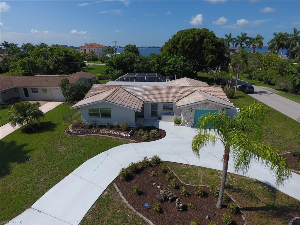 Fantastic  pool home on oversized corner lot! This home is situated just one block from the Caloosahatchee River not
only has a wonderful location-within walking/biking distance to the Cape Coral Yacht Club and in a non-gated/NO HOA neighborhood
consisting of single family homes some in the million dollar plus range- also offers well laid out living space that has been meticulously cared for and updated. You will
love the open feel of the home with large panel slides to pool lanai, crown molding, tile flooring, a remodeled (2016) open concept
kitchen w/ crushed quartz countertops, shaker cabinets, and stainless steel appliances, and the split bedroom floor
plan. The extended screened rear lanai is perfect for spending time in the SWFL sun with heated pool. Newer A/C. Additional bonus room could be used as a den study off one of the 2nd bedrooms.Furniture is also negotiable at a reasonable price as well with some exceptions shells,bar cart and dining room table and a few other items