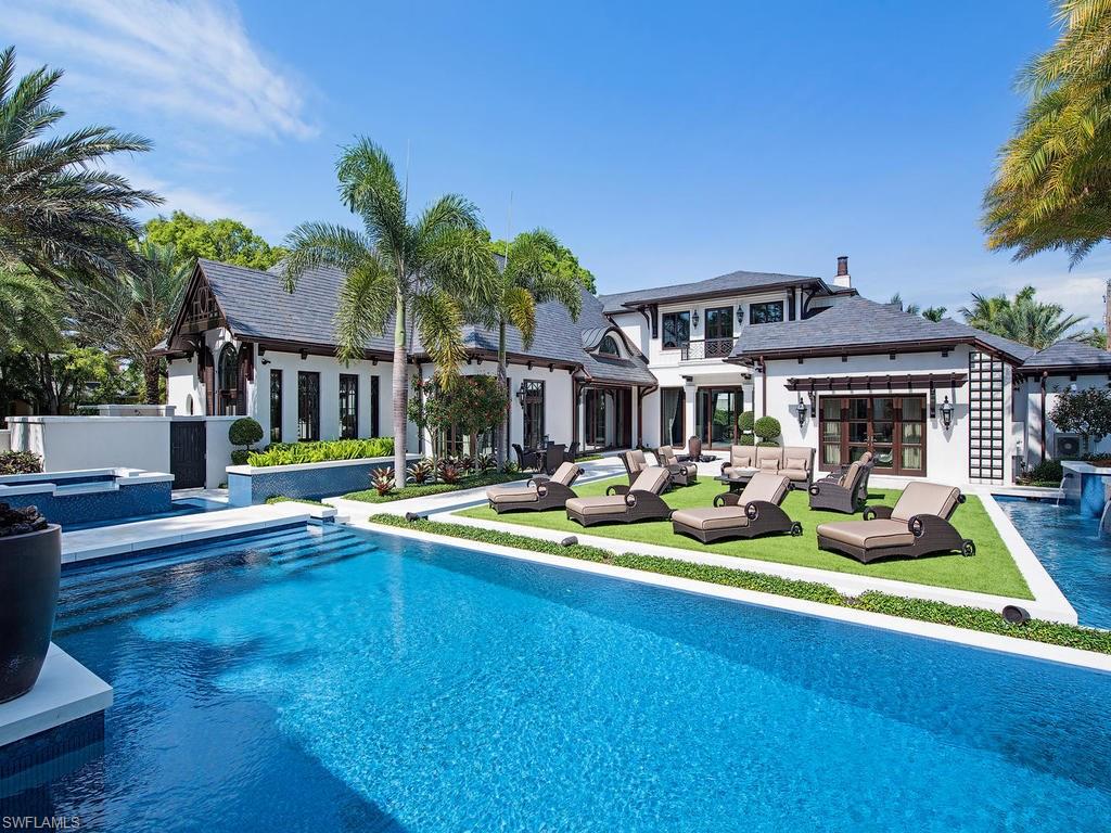 H.10762 - Iconic, timeless, spectacular...British West-Indies masterpiece thoughtfully designed by architect Jeff Harrell & built to the most exacting standards by BCB Homes.  This stately home is situated on an exceptional 200’ x 150’ site framed by massive mahogany trees.  Defined by a Buckingham black slate roof, cypress corbels & brackets, mahogany shutters, mahogany MQ windows & doors, and 18 custom-built natural gas lamps, this 7,800 square foot residence has no equal.  The main residence is comprised of 4-bedrooms suites, study, & gourmet styled kitchen with hand forged steel hood + a convertible pavilion finished in shell stone walls ideal for inside/outside entertaining.  High levels of refinement are found in exquisite old-world ironwork detailing by Belt Colombia, marble floors & walnut floors, Fine Art light fixtures, recessed electric shades plus, steam/sauna room & much more.  There is a 660 Sq.ft. guest house/cabana with full bath, laundry and a 1-car garage + room for a lift.  The elaborate pool area has elements of flowing water through long runnels, fountains and cascading edges finished with custom glass tile.  This magnificent home truly is a work of art.