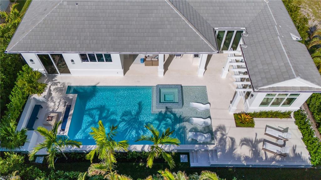 New construction! This exquisite Park Shore residence by Borelli Construction blends elegance, functionality, and modern luxury. The thoughtfully designed floor plan features a spacious great room, a gourmet kitchen with abundant storage, a working pantry, and four bedrooms with four full baths—plus a cabana with a half bath connected by a charming breezeway. Natural light pours in through southern exposure and fully pocketing 10-foot sliders, seamlessly connecting indoor and outdoor spaces. The interiors showcase European wide-plank white oak floors and detailed ceiling trim that elevate each space. The primary suite offers a sitting area, custom-built closet, and a spa-like marble bath with dual water closets and a luxurious wet room. Outside, experience the oversized pool with a sun shelf, integrated spa, and sunken fire pit framed by lush landscaping. The expansive pool deck and covered lanai—complete with screens, shutters, an outdoor kitchen, a white-washed cypress ceiling, and a fireplace—create the perfect retreat. Additional upgrades include a whole house water purification system, SubZero/Wolf appliances, Control4 and Lutron home automation, hard-wired electric shades, a 1,000-gallon propane tank, and a whole-house generator. Clive Daniel eloquently appointed this home, which is built a foot above the new FEMA base flood elevation, delivering timeless style and peace of mind.