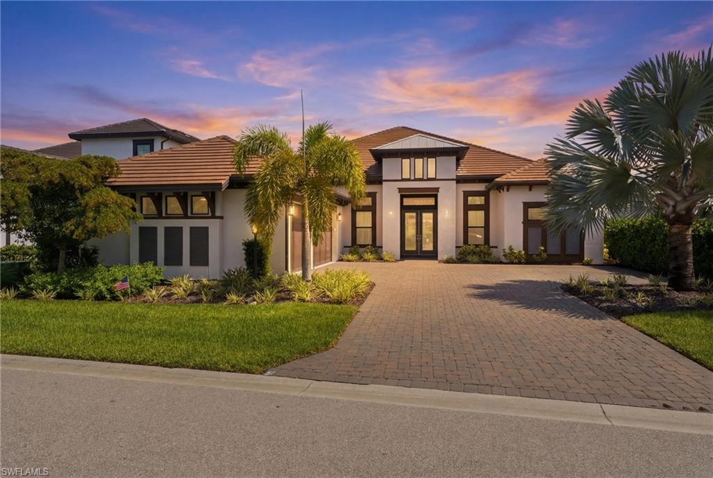 Welcome to this exceptional Beacon model residence in the highly sought-after Esplanade Lake Club, where luxury living meets resort-style amenities and an unmatched Southwest Florida lifestyle. Situated on a premium boatable homesite, this meticulously upgraded 3-bedroom, 3.5-bath home with a 3-car air-conditioned garage offers the perfect blend of elegance, comfort, and functionality. Inside, you'll find porcelain tile flooring, recessed lighting throughout, designer fixtures, custom storage solutions, and an open-concept floor plan designed for both everyday living and entertaining. The gourmet kitchen is a chef's dream, featuring premium Monogram appliances, double ovens, natural gas cooking, a wine cooler, soft-close cabinetry, custom storage, and an expansive island overlooking the living and dining areas. The luxurious primary suite offers dual vanities, an oversized walk-in shower, and separate his-and-her closets. Guest bedrooms each enjoy private bath access. Outdoor living is truly spectacular with a large saltwater pool and spa, sun shelf, natural gas outdoor kitchen hook up, Sonos sound system, and a dock for direct boating access. Additional upgrades include hurricane-impact PGT windows and doors, a whole-home generator, spray foam attic insulation, insulated garage doors, tankless water heater, extended appliance warranties, and professional landscaping. Residents of Esplanade Lake Club enjoy an unparalleled amenity package including a resort-style pool, Bahama Bar & Grille waterfront restaurant, fitness center, tennis, pickleball, bocce, walking trails, dog parks, kids playground, private lake access, boat ramp, and a full calendar of community events and social activities that create a vibrant, active lifestyle. Ideally located just minutes from Gulf Coast Town Center, Florida Gulf Coast University, Southwest Florida International Airport, and Interstate 75, this home provides convenient access to shopping, dining, entertainment, and everything Southwest Florida has to offer. Experience waterfront luxury, exceptional upgrades, and resort-style living at its finest in Esplanade Lake Club.