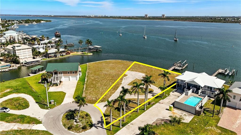 HUGE PRICE REDUCTION! Mother Nature’s Playground Meets the Ultimate in Luxury—Your future Estero Bay estate begins here. Discover a once in a lifetime opportunity to own a pristine, sprawling waterfront parcel on the prestigious North End of Estero Bay. This large, vacant lot offers nearly 90 feet of direct waterfront access with Gulf access just steps from your front yard—perfect for boaters seeking both convenience and exclusivity. Located on a peaceful cul de sac within the exclusive Matanzas Court neighborhood, this property provides the perfect blend of seclusion and vibrant island living. Imagine waking up to breathtaking sunrises over peaceful waters, enjoying evening strolls along the endless beach, and having effortless access to the Gulf from your own backyard.The seawall spans 89 feet across the rear of the property—storm damage to the dock and lift remains for future remediation. Enjoy the North End locatoin with just a short 5-10 minute walk to Times Square, Margaritaville, beachy restaurants, shops, and nightlife. The dedicated turn lane from the Matanzas Bridge ensures seamless high season access. Seeking a larger estate? The connecting Bayfront lot, (MLS #2025007037) with approved plans offers the opportunity for a larger footprint—perfect for creating an expansive compound or multiple residences. Elevate your living with direct access to the Gulf, unmatched privacy, and endless natural beauty—all within reach of Southwest Florida’s most vibrant hotspots. Imagine hosting unforgettable gatherings, indulging in picturesque sunrise mornings, or exploring the Gulf’s islands at your leisure. This is more than just land—it’s a rare opportuntiy to craft a custom coastal retreat beyond ordinary expectations. With over 15 commercial projects approved or underway across the island, now is the ideal moment to secure this special waterfront opportunity! SELLER FINANCING is available.
