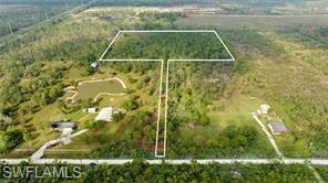 Creating your dream home on this beautiful 10+ acres is a breeze! LCEC POWER IS IN PLACE!!!? The Wetland Determination report is complete, and we have 2 acres of UPLANDS in the ideal spot for building, plus plenty of room to add a pool/spa and a barn. It’s very private, but you’ll have easy access to the property via your own private driveway. This Custom Michaela Design features a 3-car garage and a stunning, prestigious entryway. Inside, you’ll find 3 bedrooms, 3 full baths, and a half bath, a full-size dining room, a large kitchen with a huge island, a great room, a study/den, a walk-in pantry room, and a large laundry room (not just a walk-through from the garage). The primary bedroom has a large room with sliding doors to the lanai, 2 walk-in closets, a private water closet, a free-standing tub, 2 separate vanities, and a huge walk-through shower with multiple shower heads. Bedroom #3 is a second master with a private bath that leads out to the lanai, perfect for a pool bath. The great room boasts 11’4” tall ceilings, and to top it off, there’s an outdoor kitchen to complete this luxury home!!! You can make all your own custom selections, from the roof to the doorknobs! Building a custom home on this 10 acres is a wonderful way to get exactly what you want! Other plans are available, or feel free to bring your own. There’s a generous allowance included for the required site work!! The close proximity to Babcock Ranch, Publix, shopping, and dining makes this a perfect location!  ***Seller Financing available for lot portion***