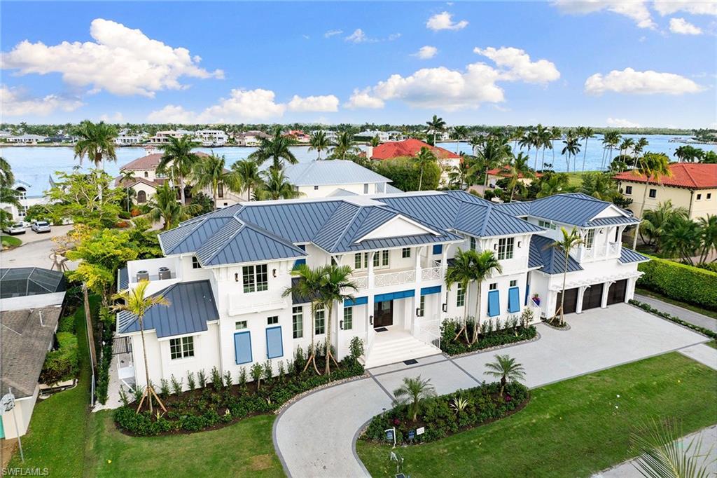 New Aqualane Shores estate situated along one of Naples' most private streets in the heart of downtown. The six-bedroom, eight-bath, Caribbean-inspired design features two swimming pools, an interior second-floor sleeping porch, oversized balconies, decks and a private cabana suite. Entertaining at home is effortless in the combined great room, dining area and kitchen. Expansive sliding doors open from the kitchen directly to the outdoor living, dining and alfresco kitchen and grill, creating a seamless transition. The primary suite showcases a generous dressing room with wraparound closet. The first floor includes a wine room, elevator, study with private exterior entrance, laundry room, butler’s pantry, powder room and a three-car garage. The great room leads to a lap pool with sun shelf and flush spa, perfect for a morning swim. A second pool with sun shelf and water feature is surrounded by a tropical environment for ultimate privacy. The second floor hosts four en-suite guestrooms with walk-in closets. A detached sixth bedroom is located above the garage with a private entrance and front balcony. Deeded boat dock accommodates a 30-foot boat with direct access to Naples Bay included just steps from the residence. Built by Waterside Builders, designed by MHK.
