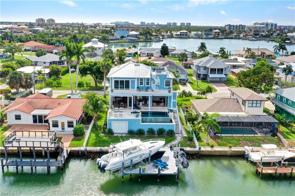***MASSIVE $300k PRICE REDUCTION - MUST GO NOW***
Experience luxury combined with island charm in this exquisite home featuring perfectly framed wide water views that will take your breath away from the second you enter. The marble floors throughout add a touch of elegance, while the sea breeze flowing seamlessly over the infinity edge pool create a perfect setting for entertaining or relaxing. The rooftop sunset deck tops everything off ideal for toasting the day's end with stunning Gulf views. The main level’s 2 ensuite bedrooms are tucked away and an expansive primary suite occupies the entire second level.  The owner’s area is a complete retreat with a private den & an impressive layout designed with precision. The walk-through closet connects directly to the laundry room, wet bar and the bathroom making this the ultimate in functionality. It also includes a hidden owner's safe for added security, all custom cabinetry & the den could convert to a 4th BR.  Back on the main level, the kitchen’s expanded bar area is perfect for serving up all the new friends you will acquire & all provisions are easily brought up by the elevator.  The dock is a boater’s delight with a robust 28,000 lb boat lift, 50 Amp shore power, 2 jet ski lifts & composite decking to accommodate all your water toys. And not to forget the car enthusiasts, the spacious garage can hold 4 or more cars with plenty of room for lifts & your golf cart...as this is the best way to visit all the tiki hut restaurants on the island.  This space also has immense potential for a man cave & has a rear back door for quick dock access.  From one Caprier to a potential other...it's the kind-hearted people that live here, the beauty of the water & the wildlife that surround us & the bond that you create here as island family...that is truly unsurpassed & quite simply super rare to find these days. Come see what Isles of Capri is all about & experience elevated island living you won’t find anywhere else!