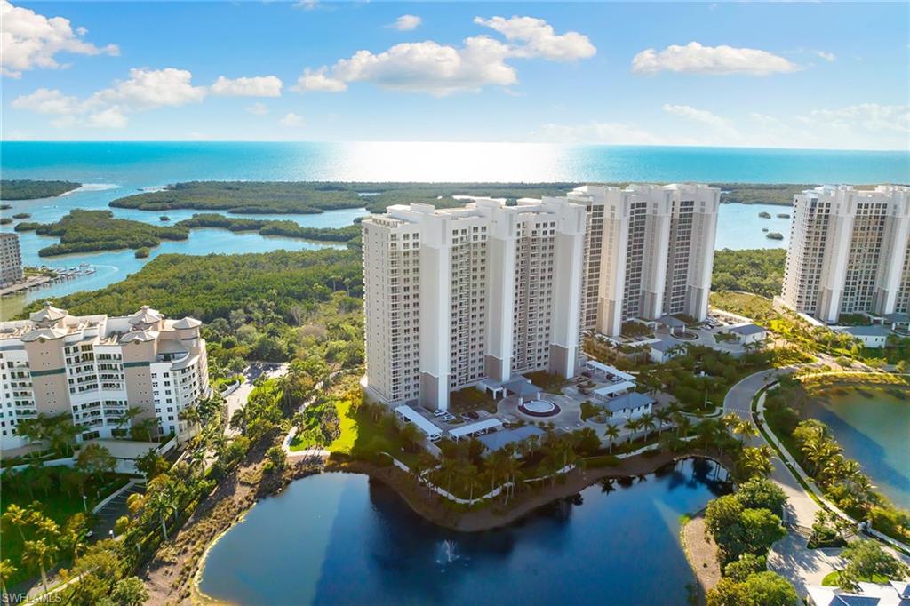 Enjoy resort-inspired living in this beautifully finished end residence at Kalea Bay Tower 100, offering a refined coastal aesthetic and an elevated, effortless lifestyle. Thoughtfully designed with an open layout, high ceilings and floor-to-ceiling window walls, the living spaces are filled with natural light and open to a spacious covered balcony with glass railings and a stunning panoramic view. The gorgeous kitchen is well-appointed with a breakfast bar, premium Wolf and Sub-Zero appliances, natural gas cooktop and an adjacent butler’s pantry. Wood flooring runs throughout the living spaces, enhancing the clean, coastal feel. The primary suite features a custom walk-in closet and a spa-like bath with dual vanities, soaking tub and walk-in shower. Three additional guest suites, each with access to a full bath, along with an additional balcony. A secured lobby with elevator access opening directly into the residence, in-residence laundry and garage parking complete the residence. The building features its rooftop terrace with pool, lounge and seating areas, and an open-air fitness center. Kalea Bay’s resort-style amenities include gated entry, amenity center with clubhouse, restaurants, poolside dining and bar, three pools, fire pits, fitness center, tennis, pickleball, game room, guest cottages, beach shuttle and more. Live every day like a vacation within one of Naples sought-after communities.