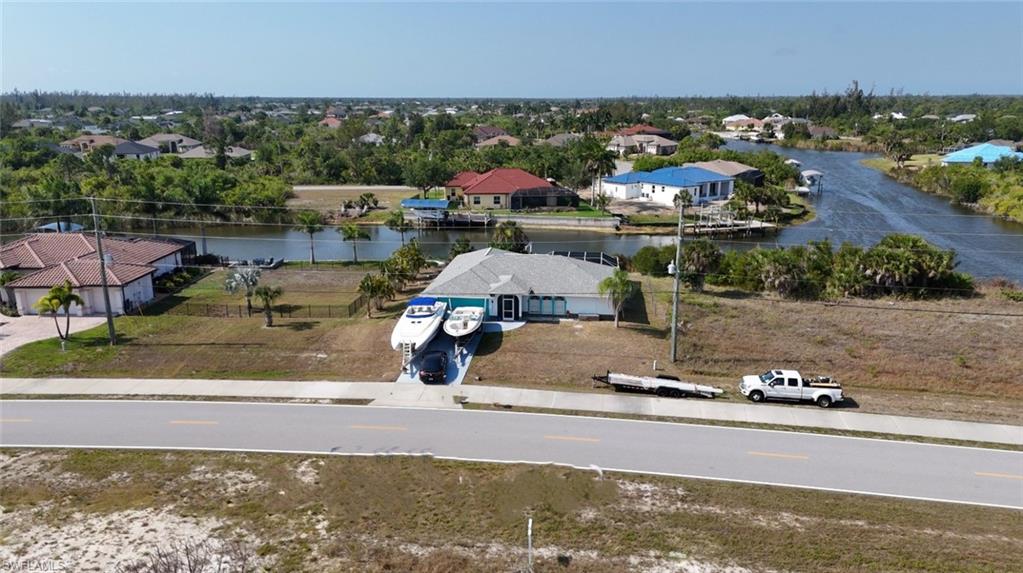 Experience true Florida waterfront living in this fully renovated 3-bedroom, 2-bathroom home, ideally positioned on a wide canal with 86 feet of frontage along the Autry Waterway and direct access to Charlotte Harbor and the Gulf.This property offers the perfect balance of lifestyle and investment opportunity, currently occupied by a tenant—providing immediate income from day one. Designed to enjoy both indoor and outdoor living, the home features a private saltwater pool (installed in 2017) and a covered lanai ideal for relaxing or hosting gatherings. A brick paver walkway leads you to the dock, complete with a 15,000 lb boat lift (2016), making it a standout choice for boating enthusiasts, Inside, the spacious primary suite serves as a private retreat with direct pool access, sliding barn doors, a walk-in closet, and a large walk-in shower. Two additional bedrooms and a full bathroom offer comfortable accommodations for family or guests, Recent upgrades include a new roof (2022), adding value and peace of mind.Whether you're looking for a waterfront residence, seasonal escape, or an income-producing property, this home presents a compelling opportunity in a highly desirable setting.