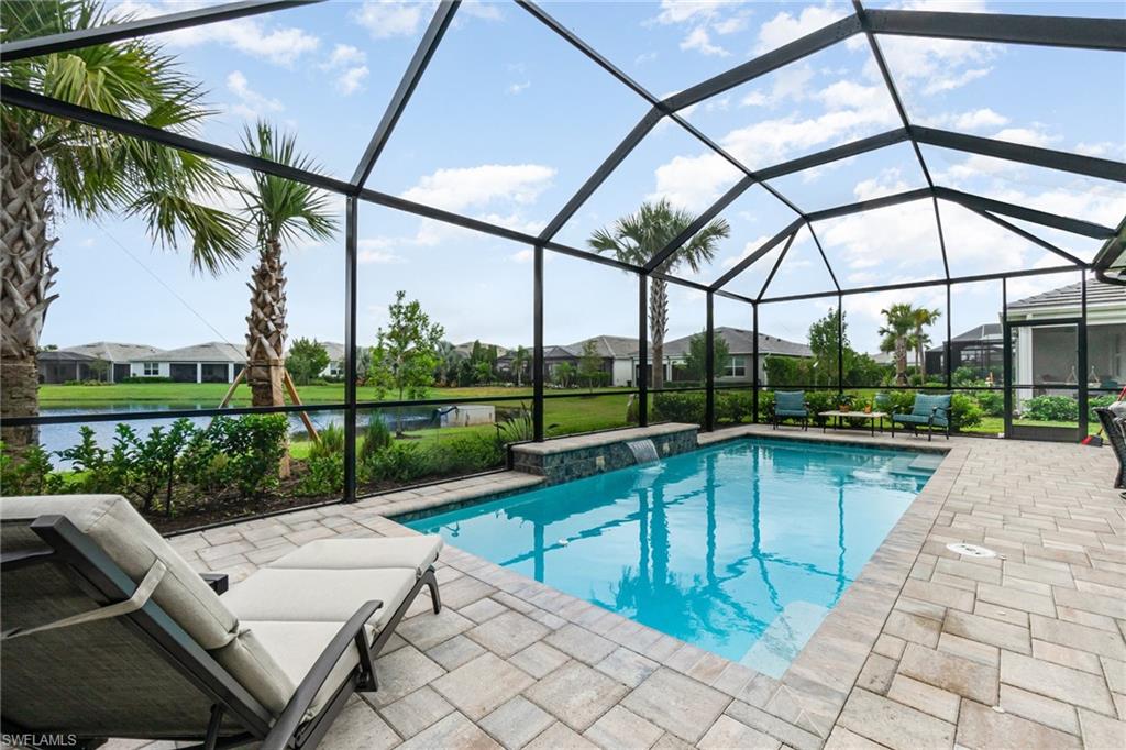 IMMEDIATE MOVE-IN LAKEFRONT OPPORTUNITY WITH PREMIUM UPGRADES, CUSTOM HEATED POOL & OUTDOOR KITCHEN! This rarely available Mystique floor plan offers lakefront living on a street with no nearby construction, delays, or disruption—making it an exceptional alternative to new construction inconveniences and expensive lot premium costs. Enhanced with extensive post-builder upgrades, this move-in-ready residence features an extended and upgraded lanai designed beyond builder standards, complete with a fully equipped Built-In OUTDOOR KITCHEN including rotisserie grill, vented hood, beverage refrigerator, sink, built-in speakers, Wi-Fi boosters, and a dimmable outdoor lighting package, all overlooking the CUSTOM POOL & tranquil LAKE VIEWS. Inside, the open-concept living, kitchen, and dining areas are oriented to maximize water views through triple and double pocket sliding doors, creating a strong indoor-outdoor connection ideal for entertaining and everyday Florida living. The kitchen offers 42-inch upper cabinetry, generous counter space, and a functional layout often offered at a premium with new construction. The primary suite includes a spa-inspired ensuite with walk-in closet and linen storage, while the guest bedroom and bath provide privacy for visitors, and a FLEX ROOM with custom cabinetry adding additional living space.  Additional features include hurricane IMPACT WINDOWS & DOORS, smart outlets, and an oversized Tandem garage that easily accommodates 3 CARS with EPOXY-finished floor. Located within the amenity-rich Del Webb Oak Creek community offering resort-style pools, fitness center, sports courts, activities, and an on-site restaurant, this home delivers immediate enjoyment of the Florida lifestyle without the wait, added costs, or uncertainty of building new.
