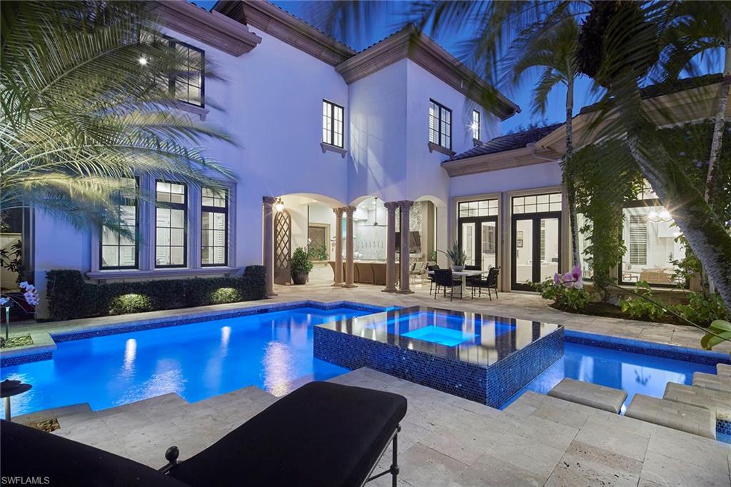 On an exceptionally private end homesite with long-range lake views, this fully renovated residence is located within the exclusive Medici enclave of Mediterra Golf & Country Club. Offering just under 5,000 square feet of elegant living space designed by Collins and Dupont, the four-bedroom plus study home showcases soaring ceilings, wide-plank oak flooring with intricate inlays and parquet patterns, and statement Hubbardton Forge lighting throughout. Upon arrival, you are welcomed into a stunning secluded courtyard featuring a renovated saltwater pool and raised floating spa with 360-degree spillover, creating an immediate sense of resort-style living and tranquility. The incredibly private outdoor living space is ideal for entertaining and includes an outdoor kitchen with a 36-inch Hestan gas grill, covered living area with a modern linear gas fireplace and mounted TV, and automated screens, allowing for year-round enjoyment of Naples indoor-outdoor lifestyle. The dramatic rotunda entry features an impact glass and metal front door and leads into the elegant living room, highlighted by soaring ceilings, a linear gas fireplace, and three sets of French doors that flow seamlessly to an inviting patio overlooking long-range lake views.  The fully reimagined gourmet kitchen serves as heart of the home and features Ruffino custom cabinetry, Sub-Zero refrigerator and freezer with adjacent wine column, an eight-burner Miele gas range, striking porcelain countertops and backsplash, oversized island and dual sinks. The primary suite offers a serene retreat with a wall of glass overlooking the lake, complemented by a spa-inspired bath with Zen-like finishes, dual vanities, a freestanding soaking tub and dual custom closets. Guests will enjoy two generous en-suite bedrooms on the second level, along with a convenient morning bar, while a detached cabana provides flexible space for a guest suite or office. Additional features include a whole-home 40-kilowatt generator, three-car attached climate-controlled garage and a natural bug-repellant system. Mediterra residents enjoy an exceptional lifestyle with two Tom Fazio–designed championship golf courses, a Gulf-front beach club and restaurant, tennis and pickleball courts, an updated clubhouse, and a soon-to-be-expanded sports and lifestyle center.