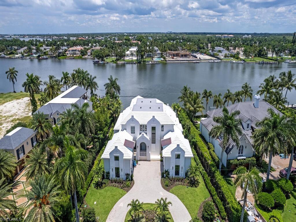 This stunning Dutch-West Indies masterpiece designed by Stofft Cooney Architects is ideally nestled on Kings Town Drive and offers expansive Bay views of Treasure Cove.  Enveloped by lush tropical landscape, the 7,745 sq. ft. estate hosts 5 bedrooms + Den, 5 bathrooms, and thoughtfully selected finishes that would please the most discerning buyer, including black walnut wide plank floors, Turkish Limestone cladding and embellishments, motorized solar shades, and stained cypress ceilings and soffits.  Upon entering the custom mahogany front door, herringbone-laid black walnut flooring lead you through the main living space to a gourmet kitchen, optimal for entertaining, that will be fitted with a large island, top-tier gas appliances, as well as quartzite stone, marble, and shellstone countertops.  From the private outdoor space, residents can enjoy a serene setting from the infinity-edge pool’s sun shelf,  craft a meal using the outdoor kitchen, or enjoy a quiet evening near the fireplace.  With only steps to the Port Royal Club, this home offers the ultimate coastal lifestyle. Ownership of this residence provides eligibility for a Primary Membership in the Port Royal Club.