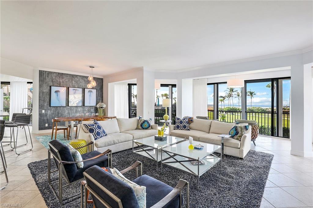 This prized '01' stack floor plan offers over 3,320 square feet of sensational open living - family, dining and kitchen areas - all with sweeping, panoramic waterfront views. Step outside to your own private patio for alfresco dining under the stars or stroll down to the beach directly from your living room. This stunning 3-bedroom plus den, 3.5-bath condo lives like a home and is offered designer turnkey furnished with the refined detailing of a luxury beachfront residence. Perfect for entertaining family and friends, the oversized chef's kitchen with a large center island features superb quality appliances and three dining areas. A separate wet bar boasts a sink, wine cooler and icemaker. Extra storage galore in the large butler's pantry with second refrigerator. Dramatic 9' 5" ceilings and countless luxury details including 2-zone HVAC, updated mechanicals, electric hurricane shutters and 2 ground-level parking spaces to ensure a premium experience. World-class concierge amenities of Monaco Beach Club, stunning views showcased from every room and direct beach access - this is an opportunity not to be missed. Investors take note - higher building elevation ensured no stormwater entry.
