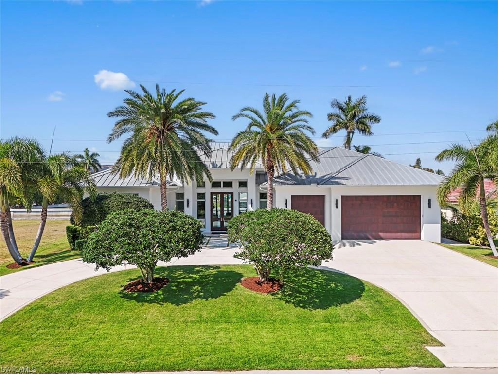 A thoughtfully designed waterfront residence created for comfortable everyday living and memorable entertaining. This like-new home offers 4 bedrooms plus a den, 3 full bathrooms, and a half bath, with a functional and flexible layout that easily adapts to a variety of lifestyles. The outdoor living space is a true highlight, featuring an infinity-edge lap pool, expansive composite decking, and a spacious covered lanai designed for year-round enjoyment. The fully equipped outdoor kitchen includes a Wolf grill, beverage refrigerator, and ice maker, while the adjacent den opens with sliding glass doors on two sides, creating an ideal space for relaxing or hosting guests. Boating enthusiasts will appreciate the private dock with a 14,000-lb lift and dedicated gear storage, making access to the water easy. Inside, the home is clean, refined, and filled with natural light, enhanced by an abundance of transom windows throughout. The kitchen is outfitted with Sub-Zero and Wolf appliances along with a wine refrigerator, and upgrades such as motorized shades add everyday convenience and comfort to the living spaces. The den offers flexibility as an additional living area, clubroom, or private office. Additional features include a 3-car garage with organized fishing gear closet, a fully decked attic for extra storage, and a portable generator. With direct Gulf access and no bridges, this property is ideal for boaters who want the convenience of being just minutes from the restaurants, shops, and vibrant lifestyle of downtown.