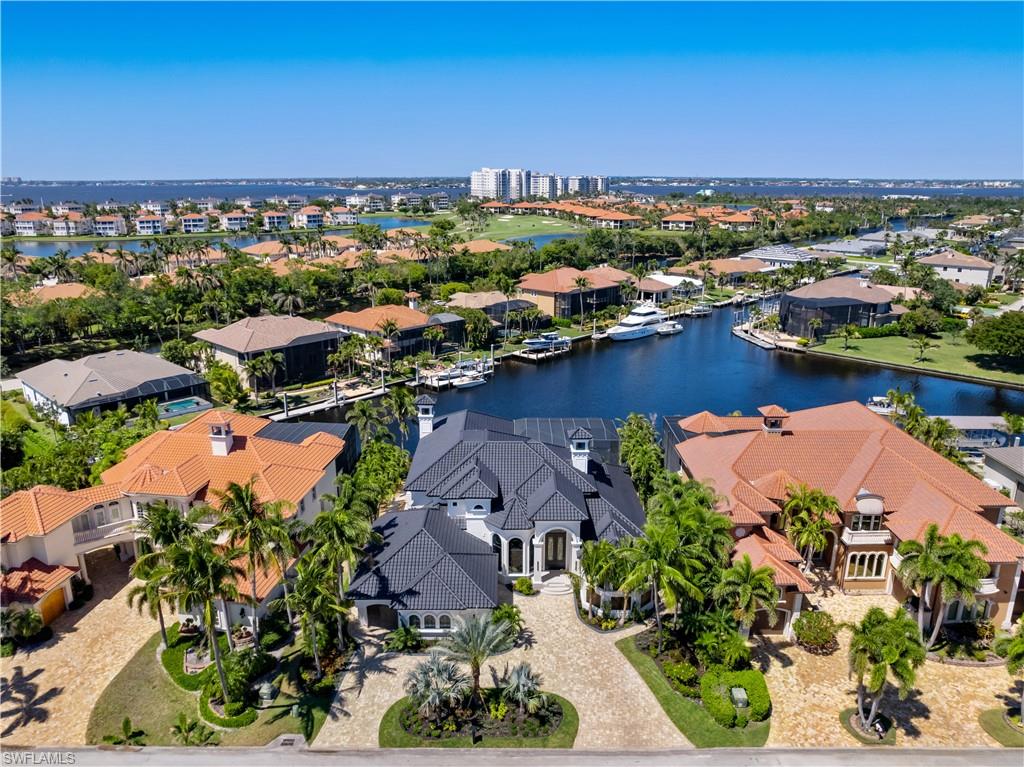 Experience unparalleled waterfront luxury in the prestigious deep-water boating community of Palmetto Point. This exquisite move-in ready residence has been completely reimagined, blending coastal contemporary elegance with upscale finishes and thoughtful design. Inside, an open floor plan with soaring ceilings and expansive windows fills the space with natural light, offering breathtaking views of intersecting canals and stunning western sunsets. The floating ceiling detail adds architectural interest, while light wood tones are beautifully balanced with deeper accents for a sophisticated aesthetic. The gourmet kitchen is a chef’s dream, featuring Wolf appliances, sleek countertops, and custom cabinetry. A temperature-controlled wine room provides the perfect space for collectors. Each of the four ensuite bedrooms offers comfort and privacy, while a media/billiards room ensures entertainment for all. Step outside to a resort-style outdoor living space, complete with wood beamed ceilings, built-in BBQ, two spas, and a large pool—all designed for ultimate relaxation. A concrete floating dock accommodates a 95’+ yacht, making this an exceptional retreat for boating enthusiasts. Additional features include a new roof, A/C workshop, and a three-car garage. This is truly waterfront living at its finest. Don’t miss your opportunity to own this extraordinary home in one of SWFL’s most coveted boating communities!
