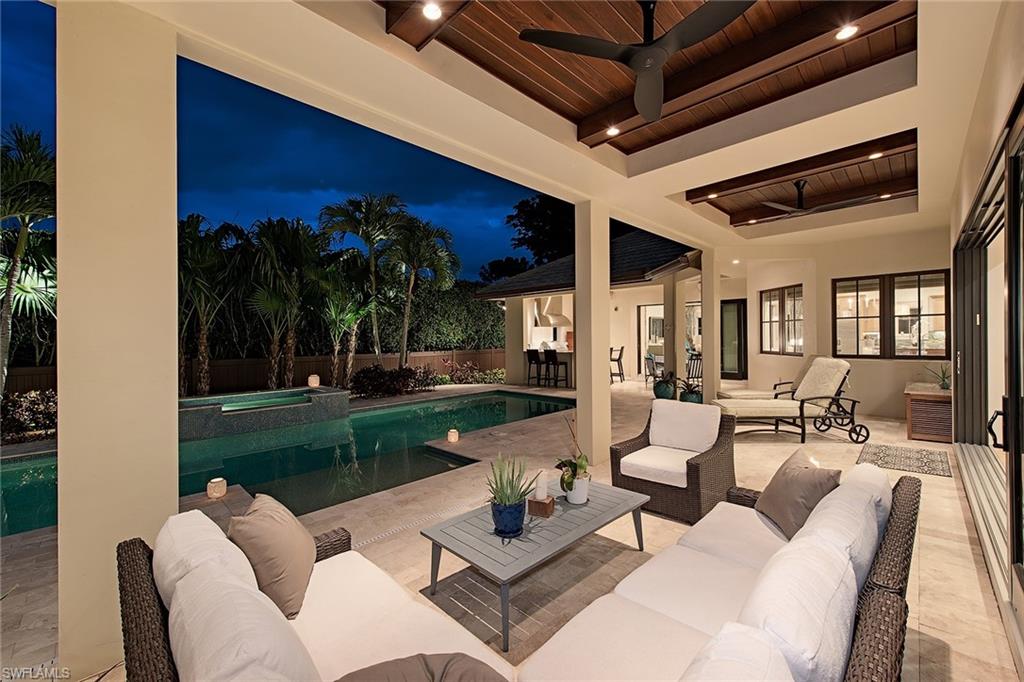 This thoughtfully executed and remarkably comfortable home is an Entertainer's Dream. Ideally situated on a spacious, private corner lot with a paved circular driveway, lush landscaping and a large fenced yard perfect for children or your furry friends. The gourmet kitchen is a cook’s dream. It boasts a large island & breakfast nook, Wolf range/oven, two dishwashers and sinks, wall oven, and a Sub-Zero Refrigerator. This kitchen transitions harmoniously to the expansive great room and dining room which includes a 500 bottle temperature controlled walk-in wine cellar.  The first-floor master suite provides the convenience of ground floor living while three large bedrooms and a second-floor large entertainment/bar area, offer generous accommodations for family and guests. All first-floor rooms have access to the incomparable covered outdoor living space, pool, summer kitchen/bar, marble patio and fenced yard. This home is energy efficient with two tankless water heaters, a gas heated pool/spa, 4 ACs, IMPACT windows & pocket sliders. Near Moorings Beach and Downtown Naples.