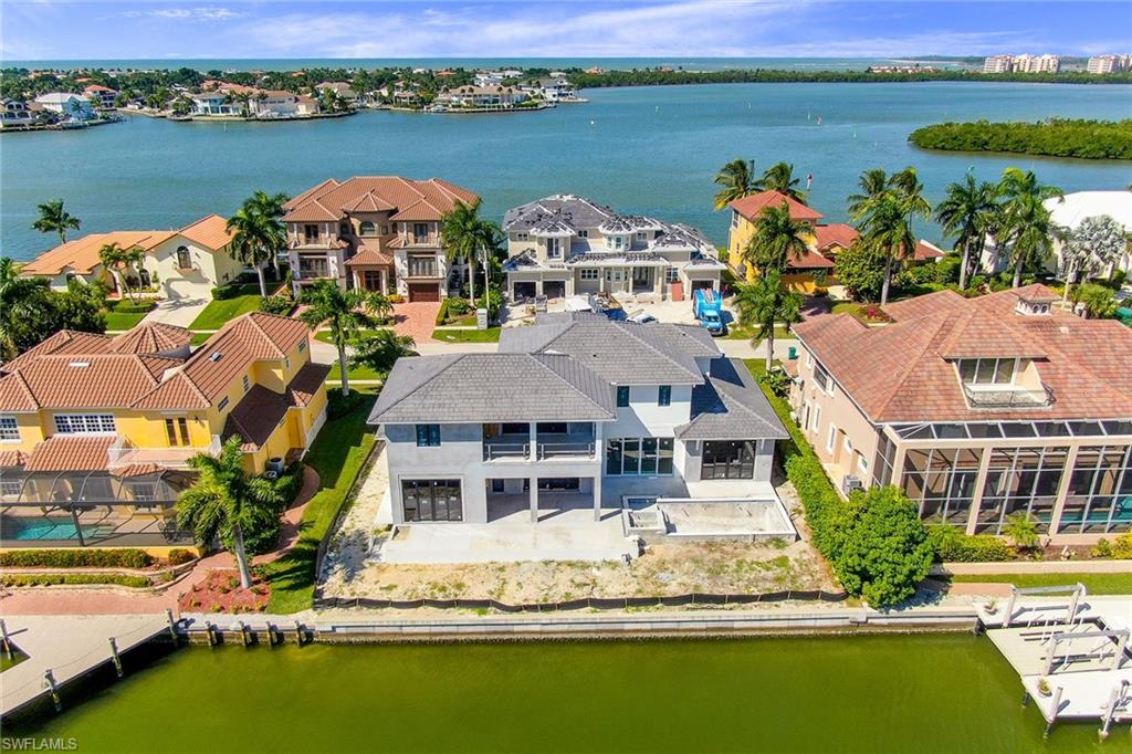 One of the most magnificent homes ever constructed on Marco Island. Built in 2020 by well-known Naples builder The Lykos Group and innovatively designed by Lotus Architecture. This home is approximately 5,370 square feet under air and 6,990 square feet total. Inside, the stunning quality kitchen with custom cabinetry, high-end appliances by Wolf & Sub-Zero, and a large island for a chef and entertainer's dream. The home features exquisite interior finishes, five bedrooms, 5 full baths and 1 half bath, an elevator, and an extensive pool complex with spa and outdoor kitchen and screened-in entertaining area. Indoor-outdoor living is seamless with the custom fold-away sliders from the great room to the pool deck and sliding glass doors from the kitchen to the outdoor area. Further enhancements include 10’ wide white oak wood floors, solid core interior doors, high-end plumbing fixtures and audio and visual home system. Additionally, the home has an oversized 3-car garage, and a luxurious, well-designed landscaping package. With unmatched craftsmanship throughout and award-winning design, this immaculately constructed home is a perfect sanctuary.
