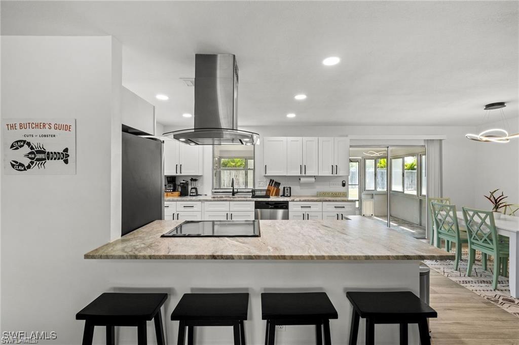Experience the perfect blend of comfort, style, and convenience in this beautifully renovated 3-bedroom, 2-bath home located in the highly desirable SE Cape Coral area. Designed with an open-concept layout, the home features wood-look tile flooring throughout, a modern neutral color palette, and tasteful upgrades that create a bright, inviting atmosphere.

The spacious living area flows effortlessly into the stunning kitchen, complete with crisp white cabinetry, stainless steel appliances, ample counter space, and a large breakfast bar—ideal for everyday living and entertaining alike. The adjacent dining area is highlighted by contemporary lighting, creating the perfect setting for family dinners or hosting guests.

Sliding glass doors lead to a screened lanai where you can relax and enjoy Florida's year-round sunshine. The fully fenced backyard provides privacy with plenty of room for outdoor gatherings, pets, or future enhancements.

Ideally situated just minutes from Downtown Cape Coral, waterfront dining, shopping, entertainment, parks, and some of Southwest Florida's most beautiful beaches, this move-in-ready home offers the Florida lifestyle you've been looking for.

Don't miss the opportunity to own this exceptional property in one of Cape Coral's most sought-after locations!