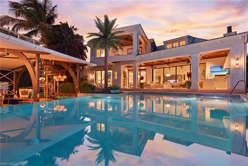 A boater’s paradise in the heart of Aqualane Shores on prestigious 4th Street South, showcasing wide water views across Aqua Cove and direct Gulf access along one of Naples’ most coveted waterways. This exceptional waterfront estate features 4 spacious bedrooms plus a private office, 4 full baths, 2 half baths, and a thoughtfully designed living space created for indoor-outdoor living. Fully pocketing glass doors connect the gourmet kitchen and expansive great room to the covered lanai, pool, spa, and waterfront areas, creating effortless flow for entertaining and everyday living. The kitchen is appointed with premium appliances, custom cabinetry, designer finishes, and an oversized island ideal for gatherings. The luxurious primary suite features tranquil waterfront and pool views, dual custom walk-in closets, freestanding soaking tub, oversized walk-in shower, paired marble vanities, skylight, outdoor shower and a private terrace with motorized screens. Additional highlights include a whole-house generator, standing seam metal roof, 3-car air-conditioned garage with room for lifts, motorized lanai screens, wide-plank Acacia walnut flooring, tray and coffered ceilings, Lutron lighting system, Sonos surround sound, and Andersen impact-resistant windows and doors. Resort-style outdoor amenities include a gas-heated saline infinity-edge pool and spa, expansive lounge areas, and a completely rebuilt ‘grandfathered’ boathouse with covered boat slip, lifts, and rooftop sun deck. Ideal for enjoying the Naples waterfront lifestyle and breathtaking sunset skies. Built by Hemmer Construction, designed by Jeff Harrell Architects, and finished by LDL Interiors, this residence blends sophisticated architecture with refined finishes and exceptional craftsmanship. Cruise to the Gulf or walk to the beach in minutes while enjoying close proximity to fine dining, luxury shopping, and downtown Olde Naples.