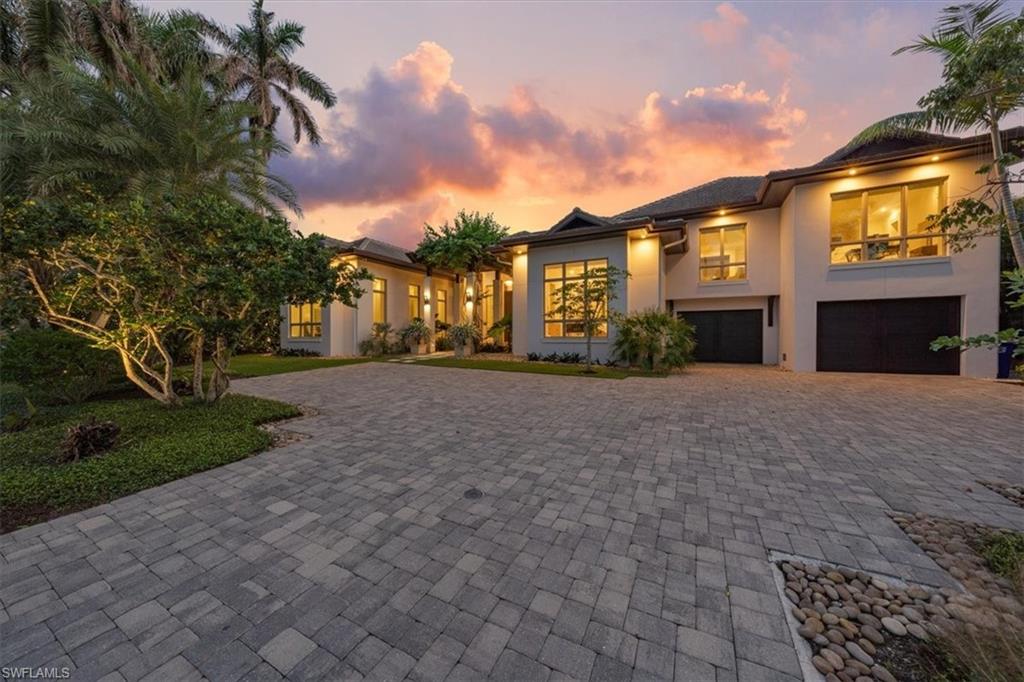Surround yourself with elegance and beauty in this classic waterfront home in prestigious Aqualane Shores. With a three-car garage and nearly 5,000 square feet of elegant yet comfortable living space, this bespoke residence features five bedrooms with en suite baths, plus all of today’s modern conveniences. Home automation, sound and security camera systems, Vantage low-voltage lighting, a home generator, natural gas, and fiber internet make for easy living. The outdoor area includes a large, covered kitchen with a fireplace, warmly accented by cypress tongue-and-groove ceilings and protected by electric roll-down shades and hurricane shutters. Unique indoor features include wide-plank oak wood flooring, Ruffino custom cabinetry, quartzite and natural stone countertops, floor-to-ceiling windows, and a 1,000-bottle temperature-controlled wine room. With nearby gulf access, the oversized south-facing waterfront lot features IPE dockage for two boat lifts (4,500 and 27,000 pounds), a 46-foot lap pool and spa, and an outdoor shower.