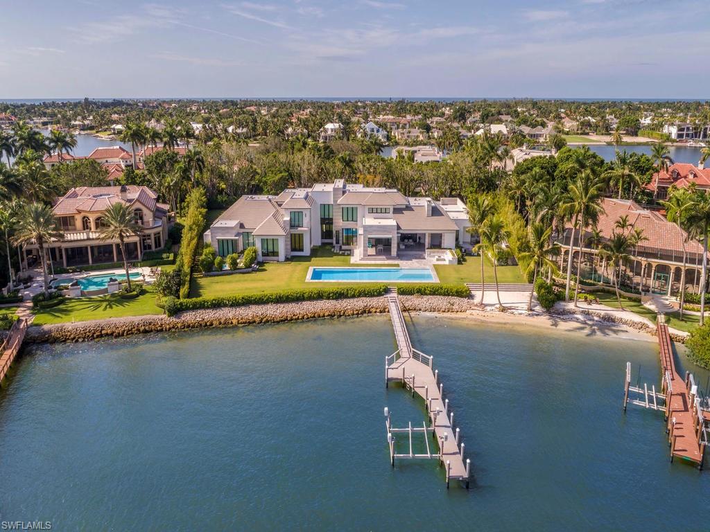As the featured cover story in Florida Home and Design magazine...Sweeping water vistas and contemporary interiors are a sublime match at this superb modern property.  This stunning estate completed in 2017,  and designed by Stofft Cooney is set on nearly 1.5 acres.  The home is crafted from the finest materials featuring, Italian white-oak floors, Bamboo veined limestone, marine grade stainless steel, and Egyptian Grey hammered natural stone. Vast sliding glass walls disappear for seamless indoor-outdoor living, leading to large lanais, outdoor kitchen, a firepit, and a 77 ft. glass-tiled pool. The expansive grounds also encompass a natural beach and oversized four-car garage.  Owners are eligible to join the exclusive Port Royal private beach club complete with spa, tennis facilities, beachfront dining, and a fitness center.