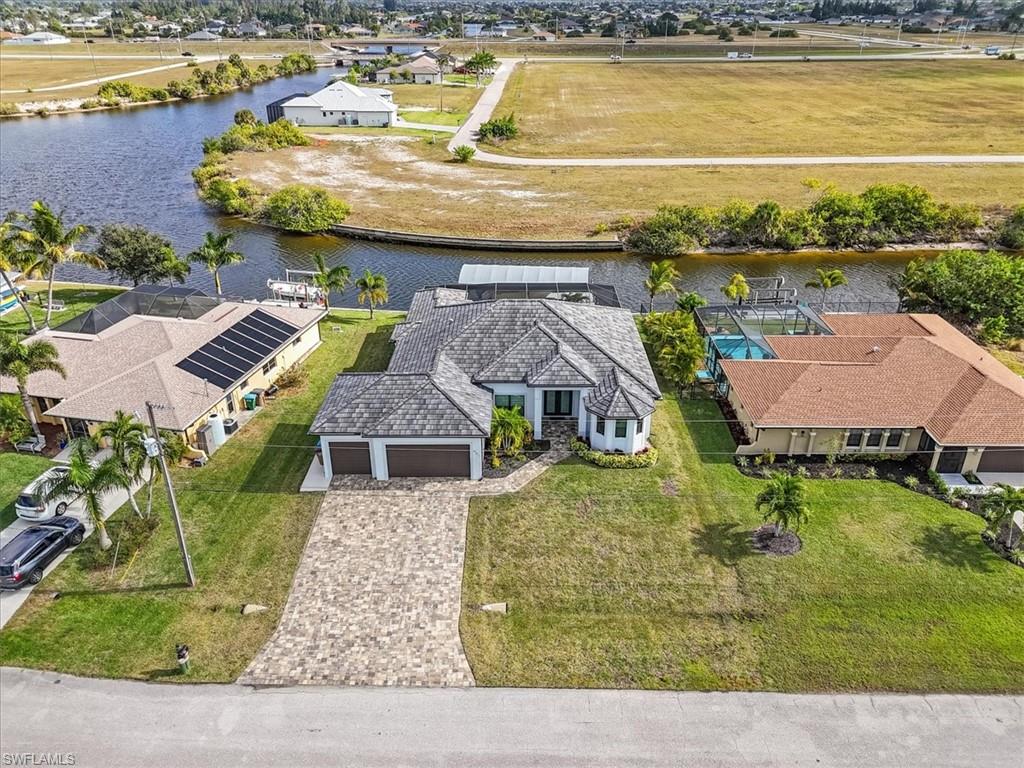 Welcome to your Dream Waterfront Home! This 2022-built custom Gulf access home in Cape
Coral offers 3 bedrooms + den and 3 baths and direct access to Matlacha Pass — perfect for boating, entertaining, and Florida coastal living.
Bright and open, the home combines contemporary design with smart, functional spaces. This exceptional residence is a true boater’s
paradise, perfectly positioned in the heart of this vibrant coastal community. Built with impeccable craftsmanship and contemporary flair, this
newer home blends luxury, smart technology, and everyday comfort seamlessly. Step inside to an open, light-filled floor plan designed for both
elegant entertaining and relaxed living. Expansive living spaces flow effortlessly, creating a warm and inviting atmosphere throughout. The
gourmet kitchen is a chef’s dream, showcasing sleek countertops high-end appliances including a smooth-top induction cooktop,
double microwave ovens, and abundant custom cabinetry for ample storage. Outdoors, your private waterfront oasis awaits. Enjoy a sparkling
pool and spa, a spacious covered patio, and endless opportunities for relaxation or entertaining. Boating enthusiasts will appreciate the
wrap-around composite dock, 10,000-lb boat lift with 16x40 canopy, and quick access to Matlacha Bay—just minutes from open water. This
property has lots to offer such as Luxurious primary bath with rain shower heads and 6-way thermostatic valves. Ultra-quiet Panasonic 400
CFM exhaust fan LCEC GenerLink for direct generator connection, fully automated pool system with your Phone control and a 3-car garage
with epoxy floors. Conveniently located near shopping, dining, entertainment, world-class beaches, and endless outdoor recreation, this
extraordinary home offers the ultimate Florida waterfront lifestyle.