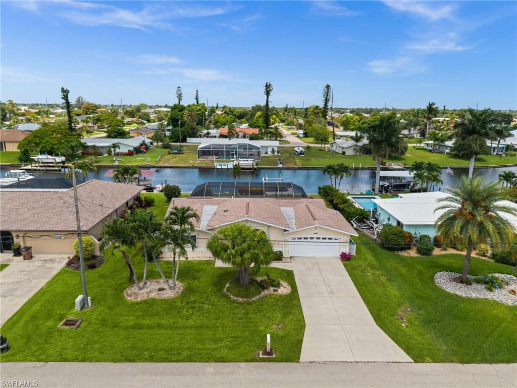 AFFORDABLE GULF ACCESS WATERFRONT POOL HOME ON CAPE CORAL’S FAMOUS 100' WIDE SAN CARLOS CANAL! Ideally located in SE Cape Coral near downtown restaurants, shopping, and conveniences, this 3-bedroom, 2-bath pool home offers 1,614 square feet of living space, a 2-car garage, and QUICK BOATING ACCESS to open water. Mature tropical landscaping welcomes you home, while the backyard is designed for enjoying the Southwest Florida lifestyle with a screened pool, paver pool deck, large covered lanai, and both concrete and wood dock areas along the canal. Inside, the home offers an open, functional layout with plenty of sliding doors bringing natural light and pool views into the main living spaces. The kitchen features lots of cabinets, a center island, and convenient access to the enclosed sunroom, creating additional flexible space for dining, relaxing, or entertaining. The dining area includes built-in shelving, while the interior laundry closet includes a washer and dryer. The primary bathroom also serves as a pool bath, with direct access to the lanai and pool area. ROOF 2021. Whether you are looking for a full-time waterfront residence, vacation home, or investment opportunity, this is a great chance to own Gulf access waterfront in a convenient SE Cape Coral location.