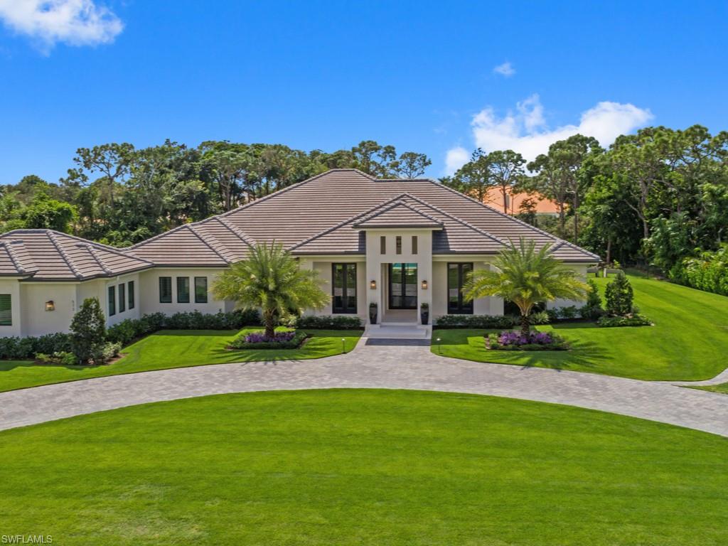 Simplistic transitional elegance in the award winning neighborhood of Pine Ridge Estates. This exquisite Lotus Architecture designed, CK Custom home boasts 5,010 Square Feet of under-air living space, featuring an expansive open floor plan with 4 en-suites, den plus a office/flex room, 4 full and 2 half baths including a pool bath. Enter this professionally decorated home through the custom double glass front doors by Portal Elegance. Once inside the attention to detail is apparent. A soaring coffered ceiling with boxed beams, layered moldings and beautiful white oak. Bespoke kitchen cabinetry and commercial grade appliances. Large scale porcelain tile and wide plank white oak flooring throughout. Beautiful marble tile wall in the kitchen which mirrors a marble fireplace in this open concept main living area. Open the custom, fully pocketing, sliding glass doors to a professionally landscaped backyard which includes an oversized salt water pool, glass tiled spa, limestone decking/coping and fire pit. Circular driveway and guest parking with turf feature. Oversized 4 car garage with A/C storage room. All of this situated on a private park like setting of 1.27 acres.