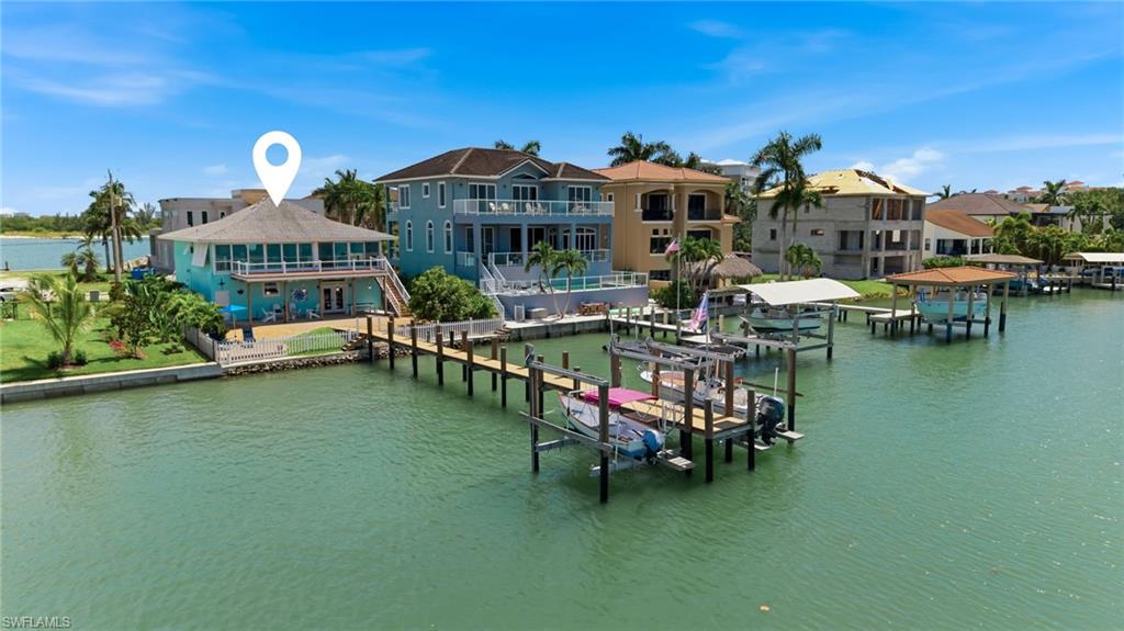 Spectacular Waterfront Living on the Isles of Capri... Wake up to breathtaking panoramic views of the largest bay on the Isles of Capri from this beautifully remodeled elevated waterfront home. With an impressive 100-foot private composite dock equipped with electric, water and two boat lifts, this property is a true boater's paradise offering direct deep water access and island beaches just beyond the bay.
This meticulously maintained 2-bedroom, 2-bathroom single-family home was extensively remodeled in 2018 and offers an inviting open layout designed to maximize the stunning water views. The lower level includes a versatile bonus area, while the oversized four-car garage provides abundant storage for vehicles, golf carts, water toys, and more.
Recent updates and features include: brand-new air conditioning system, 2024 water heater, beautifully updated bathrooms, whole-house generator and impact-resistant windows.
Whether you're searching for a full-time residence, a seasonal island retreat, an exceptional waterfront investment, or the perfect site to build your future dream home, this remarkable property offers endless possibilities. Enjoy the relaxed island lifestyle of the Isles of Capri while remaining just minutes from the world-class beaches, dining, shopping, and amenities of Marco Island and Naples.
This is a property that truly must be seen in person to appreciate the incredible views, location, and lifestyle it offers.