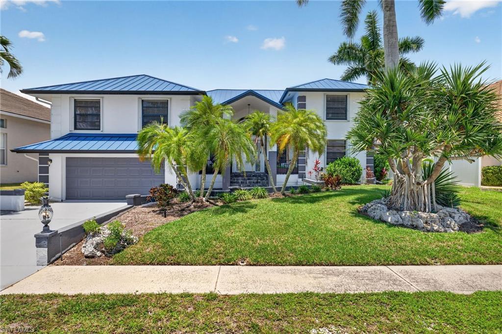 Stunning waterfront pool home with an expansive living area and ultra high ceilings. This 4-bedroom, 4-bath residence offers over 2,900 square feet of light-filled living space with  the primary suite on the main level. The open floor plan flows out to a large screened lanai and a oversized pool overlooking the canal. Boaters will love the dock with boat lift on a deep water canal, and convenient access to Caxambas Pass and the Gulf of Mexico.  Additional highlights include a 2018 metal roof, and a newer A/C. This residence is being offered turnkey furnished and just minutes from Mackle Park, beaches, dining, and shopping.