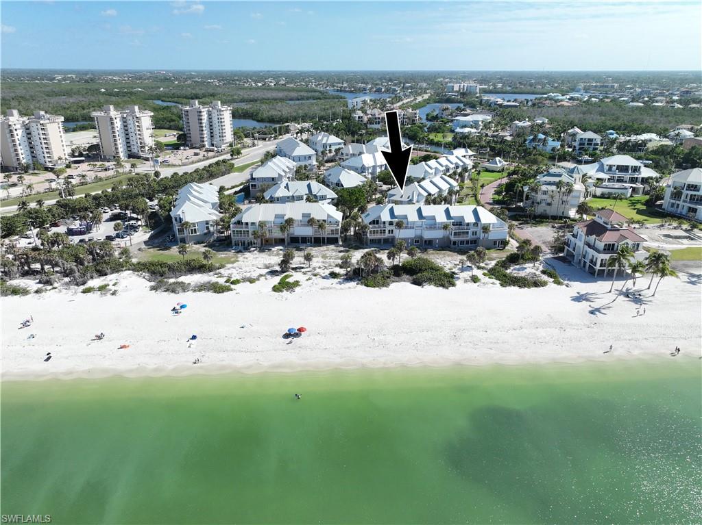 Rarely available direct beachfront villa in the Villas at Barefoot Beach. Single family ownership with HOA - you own the land. Collier County’s least expensive direct beachfront single family ownership property. This 3 story villa features 3 bedrooms, 3 baths, large great room, kitchen with casual dining & formal dining all with wide Gulf views, screened lanai with electric shutters, master bedroom plus private deck overlooks the Gulf & has large master bath. Lower level with two car garage large storage plus ground floor lanai.  Barefoot Beach is a guard gated community with 24 hour patrols. The Villas offer two swimming pools & a spa plus beach boardwalk & sunset deck on the beach.  Community pools are being renovated plus new landscaping.  Special assessments levied have been paid.