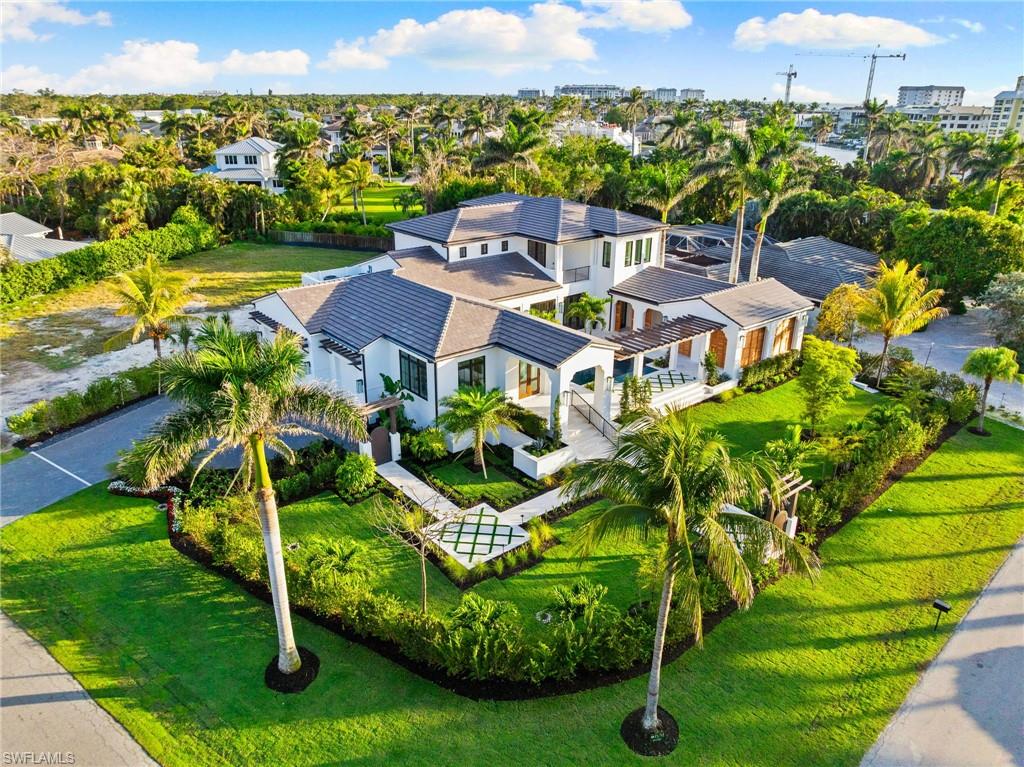 This stunning 2025-built residence is a true masterpiece. Combining the timeless charm of Santa Barbara architecture with the relaxed elegance of the Caribbean, this home offers a seamless blend of sophistication, modern luxury, and serene living.  With 5 bedrooms, a dedicated study, and a library.  The refined living space, is designed for both entertaining and intimate family moments. From the moment you enter, you'll be captivated by custom millwork Mahogany front doors, elegant architectural details of the foyer, dark Legno Bastone French Oak flooring, and the abundance of natural light pouring through large windows that bring the outdoors in. The chef’s kitchen is a showstopper, featuring a central quartzite island, custom cabinetry, and high-end appliances, including two Sub-Zero refrigerator/freezers, a 48-inch Wolf gas range, double oven, Wolf microwave, and warming drawer. The adjacent butler’s pantry with Sub-Zero beverage center and Bosch dishwasher elevates both style and function for the most discerning home chefs. The main floor includes a guest bedroom with an en-suite bath, a private den, and a library (with ice make, beverage refrigerator and 102 bottle wine refrigerator, along with a half bath and a full bath accessible from the lanai. The sun-soaked primary suite is a luxurious retreat, offering an expansive walk-through custom closet that leads into the spa-inspired bath, designed with indulgence in mind. The family room seamlessly opens to the lushly landscaped patio, featuring a summer kitchen equipped with a Sub-Zero beverage center, ice maker, GE dishwasher, and a 40-inch BBQ—perfect for year-round outdoor entertaining.  Pool is 24 x 18.5, plus the hot tub is 9.5 x 6.  The second level features a bonus room and 3 additional en-suite bedrooms. This custom-built home it’s a treat to experience as it is one of Naples finest new construction homes in the area, where every detail has been carefully designed for those with discerning taste.  Built to the latest and best codes, including a full house generator.  Moorings Private Beach Club has a very low membership fee, what other beach club can you join for $1450.