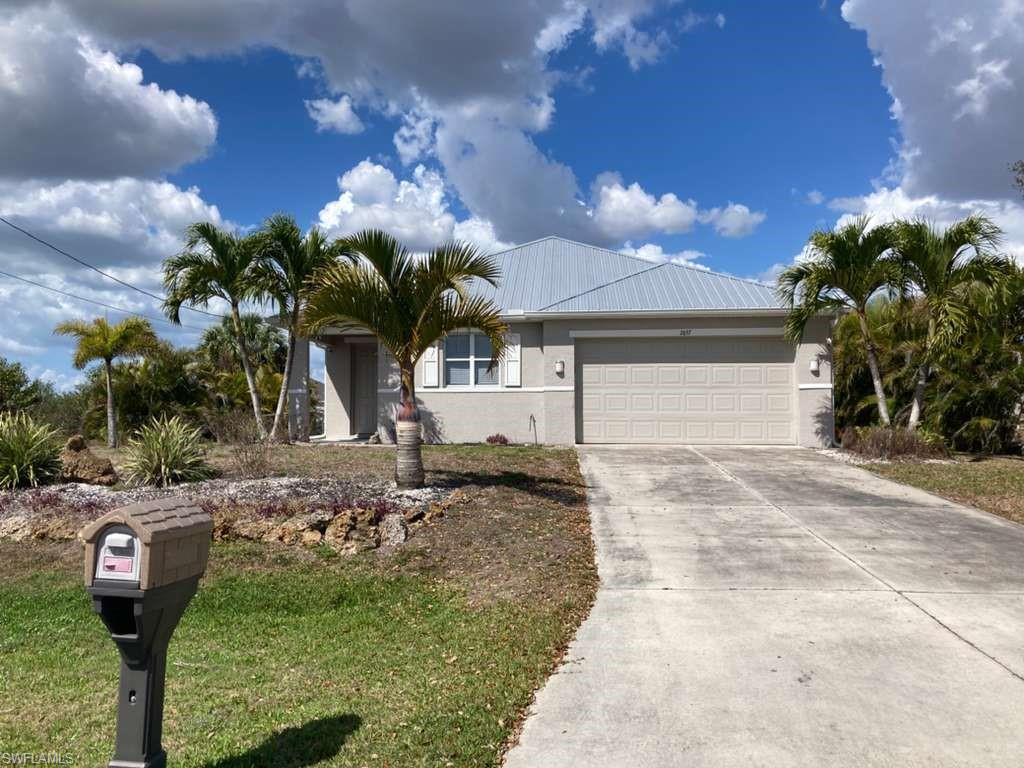 Cape Coral Waterfront Living! Nestled on a quiet freshwater canal, this spacious rully furnished 3-bedroom plus den, 2-bathroom home offers nearly 2,000 sq. ft. of comfortable, modern living space. The exterior immediately impresses with a brand-new metal roof and manicured Floratam lawn serviced by an automatic sprinkler system.Step inside to a thoughtfully designed split-bedroom floor plan featuring sleek porcelain tile throughout no carpet here! The heart of the home is a versatile kitchen equipped with solid wood cabinets, granite countertops, a center island, and a breakfast bar that opens to both a casual breakfast nook and a formal dining area. High ceilings and separate living and family rooms provide ample space for entertaining or working from home in the dedicated den/office.Relax in the primary suite, which boasts large walk-in closets and a spa-like ensuite. Outdoors, enjoy the Florida breeze from your screened-in lanai under truss, overlooking a fenced side yard with a dog run and plenty of room for a pool. With a newer AC system, new well equipment, and a move-in-ready interior, this home is the perfect blend of peace and convenience near Embers and El Dorado.