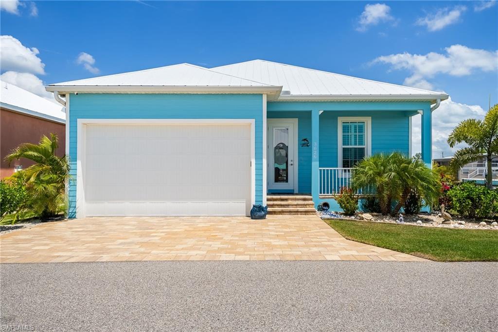 Experience the best of coastal living in this exceptional waterfront furnished retreat in Saint James City, where island charm meets modern comfort. Nestled in the laid-back boating community of Treasure Cove, this solid concrete block home with a durable metal roof is perfectly positioned for those who crave life on the water. With direct Gulf access and no bridges, your next boating adventure is just minutes away—an absolute dream for avid boaters and fishing enthusiasts. Step inside to discover a bright, open, and inviting interior with beautiful coastal furnishings designed for both relaxation and entertaining. The spacious great room features soaring volume ceilings, tile flooring throughout, and an abundance of natural light that enhances the home’s airy coastal feel. The thoughtfully designed kitchen is a standout, showcasing crisp white shaker-style cabinetry, sleek quartz countertops and backsplash, and stainless steel appliances—perfect for hosting gatherings or enjoying quiet evenings at home. The primary suite offers a peaceful escape with serene canal views, creating the perfect backdrop to unwind. The en suite bathroom includes dual sinks and a beautifully tiled walk-in shower, adding a touch of luxury to your daily routine. Two additional bedrooms provide versatility for guests, a home office, or creative space, while the in-residence laundry area and garage with built-in shelving and fishing rod storage add everyday convenience. Outdoor living truly shines here, capturing the essence of the Florida lifestyle. The screened lanai is equipped with sun shades and an electric hurricane fabric shade, as well as a security system, offering comfort and protection year-round. Step out to the paver patio—ideal for grilling and entertaining—then down to your private composite dock complete with kayak launch steps, a fish cleaning station with a light, and a 7,500 lb. boat lift with canopy. Whether you're sipping your morning coffee, hosting friends, or heading out for a sunset cruise, this home is designed to make every moment count. Located in a charming island community, you’ll enjoy a relaxed pace of life while still being close to local dining, marinas, and all that Pine Island has to offer. Whether you're searching for a full-time residence, a seasonal getaway, or a smart investment opportunity, this Gulf-access gem is your opportunity to own a true slice of paradise.