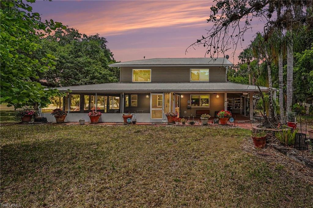 Welcome to one of the most beautiful homesites in Port LaBelle Ranchettes—a breathtaking 7.37± acre estate comprised of two Port LaBelle Ranchettes parcels, set in a magnificent park-like landscape of towering oak trees that showcase the natural beauty LaBelle is famous for. This rare property offers privacy, space, and exceptional improvements in one of the area's most desirable acreage communities. The centerpiece is a beautifully designed 4,500± square foot custom residence featuring 3 bedrooms, 2 full baths, and 1 half bath, constructed with 2x6 framing, vinyl siding, and topped with a durable Galvalume metal roof. Inside, the home is warm, inviting, and architecturally impressive. The dramatic two-story great room boasts a soaring cathédral ceiling, stunning upper-level picture windows with decorative fanlights, and a striking stone fireplace that anchors the living space. Multiple sliding glass doors open to Florida room areas, while a charming bay window reading/TV nook creates a cozy place to relax and enjoy the views. Designed for Florida living, the home is surrounded by generous outdoor living spaces, including open tiled porches wrapping nearly half the home, a screened porch, and a spacious Florida room that extends along two sides of the residence, blending indoor comfort with outdoor beauty. 
The first-floor master suite is privately tucked away behind elegant double doors and includes a spacious master bath and wall<-in closet. Upstairs are two oversized bedrooms and bath accommodations, providing comfortable private space for family or guests. The expansive chef's kitchen is built for gathering, featuring custom cabinetry, a center island with bar seating, breakfast bar, abundant workspace, and a large pantry. Just off the kitchen is a separate laundry room with half bath for convenience. A separate office/hobby room addition, complete with its own entrance and crank-out windows, offers excellent flexibility for a home office, studio, or private retreat. Interior windows are hurricane rated for added protection and peace of mind.
This impressive mini-ranch is further enhanced by outstanding exterior improvements, including a detached carport, raised concrete planting beds, separate water equipment shed, well and septic system, garden shed, and a substantial 40' x 70' insulated steel field barn with roll-up doors. Both the home and barn are security monitored. Surround yourself with neighbors who take pride in their homes, enjoy room to roam, and embrace the peaceful country lifestyle—while still being conveniently close to town. Located in the highly sought-after Port LaBelle Ranchettes, beautiful surroundings, and a sensible HOA that preserves property values by prohibiting mobile homes. With special exception through Glades County zoning, animals are permitted, making this an ideal setting for your own mini-ranch lifestyle. Come experience life at 3079 Frontier Circle, where Old Florida beauty meets refined country living.