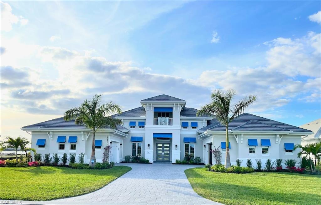 Luxurious 4,369 SF, 4-bed/5 bath Stock Development customized lakefront home with spectacular sunset views. The home features an 18x20 flex bed/bonus room, media room, formal dining, kitchen nook, & office providing flexible spaces & open living. Upgrades include a designer kitchen with double islands, custom built-in cabinets in the great room, office, dining room, bonus room & master closets; plantation shutters, motorized shades, custom drapery, iron front doors, high-end tile work, and unique ceiling designs.  Entertain in your expansive panoramic, super screened-in lanai with a custom fireplace, an outdoor kitchen with an island, a large pool & oversized spa. An additional refrigerator in the laundry room, 2 insulated 2-car garages a whole-house Generac generator, and Tesla EV connector are also included. Spacious lot with lake views from the rear and pond views from the front! WildBlue has many amenities including 8 pickleball courts, 6 tennis courts, bocce, basketball, a fitness center, fitness classes, a lap pool, and a soon-to-come resort pool with a full-service restaurant and pool grille. WildBlue is located close to the airport and shopping. Come enjoy the sun and fun!
