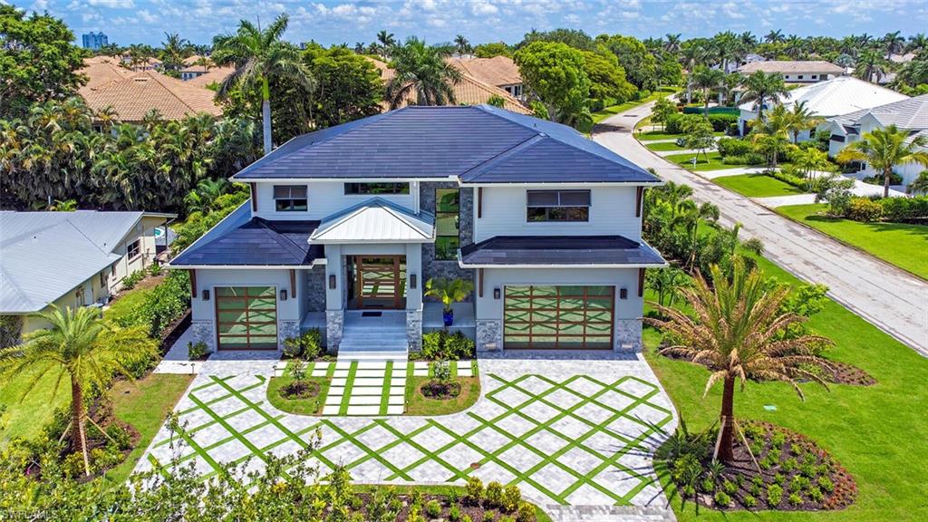 Introducing a distinguished coastal retreat. Beautifully appointed by Clive Daniel and brought to fruition by Poppa Construction, this 6-bedroom plus den residence is a masterclass in modern elegance and refined craftsmanship, nestled in the coveted enclave of Park Shore. Every detail of this home speaks to those with an eye for the exceptional. Showcasing a curated selection of exquisite stone finishes, handcrafted custom trim work, and sleek appliances including the likes of Bertazzoni; the home redefines tasteful selection. A dedicated home office provides a serene space for productivity, while a sprawling bonus room offers endless possibilities for recreation or relaxation. Outfitted with cutting-edge Tesla solar roofing (resulting in zero FPL bill since completion), SPAN smart car chargers, and Control4 whole-home automation, this residence effortlessly merges sustainability with innovation. Whether you're savoring coastal breezes on a nearby beach or enjoying the tranquil sophistication of your personalized living space, this home delivers an elevated Naples experience. Just moments from fine dining, upscale shopping, and Gulf of America sunsets, this architectural gem is the ultimate expression of coastal luxury living — meticulously built for the discerning.