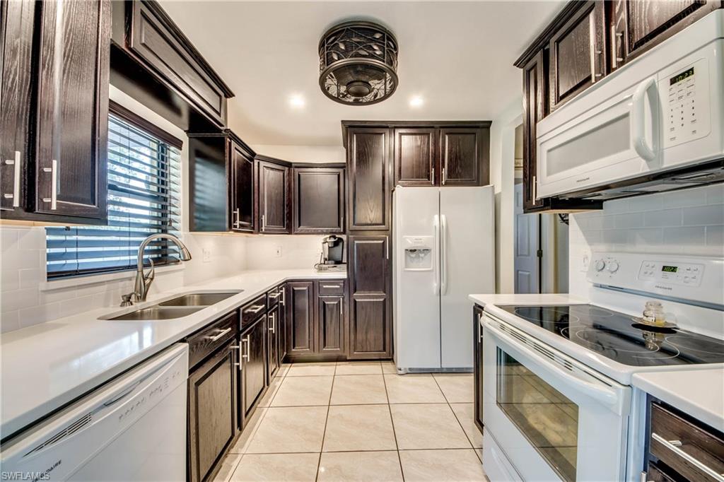 Come and see this beautifully renovated Baywood Ranch Style Home, and buy your piece of paradise.  This home is accented by many upgrades that you see as you walk through the front door.  You will immediately notice the upgraded electrical switches as you set the mood inside your family room under the high vaulted ceilings.  Tile flooring throughout with 4 1/4" baseboards.  The kitchen offers white quartz counter tops that complement the walnut cabinets.  A high speed fan that cools the chef as they prepare the family dinner. The Master Bedroom has a California closet system to organize your clothing and a recently updated master bath with rain shower, body sprayers and hand held features. Maximize your storage with 9 garage cabinets.   Included are: 6 ceiling fans, window blinds, light fixtures, appliances, washer, and dryer.  This spacious backyard  is fenced in and features a sun deck, with a 300 watt low voltage lighting system with plenty of voltage to add more landscape lighting.  Storage shed for yard equip. and plenty of room to add a pool.  New 14 seer ac unit any many other features that set this Cape Coral home above the competition.