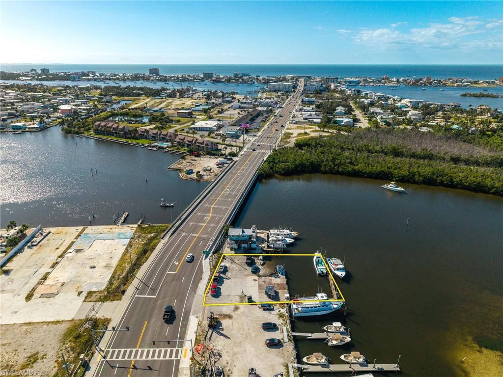 GREAT OPPORTUNITY ON FORT MYERS BEACH - BEFORE PRICES RISE AS THE AREA GROWS!

If you’ve been looking for a waterfront commercial property with Gulf access in an unbeatable location, this is one of those rare finds that doesn’t come along often.

Positioned directly on San Carlos Boulevard just about a mile from downtown Fort Myers Beach, this bayfront property sits right in the center of Southwest Florida’s busiest marine and tourism hub. With exceptional visibility, steady traffic flow, and direct access to open water, this location works for your business day in and day out.

You’re surrounded by well-established, high-performing businesses including fishing charters, boat rentals, parasailing companies, tiki tours, and other marine-focused operations. The demand is already here - this is where customers naturally come for waterfront experiences. Add in walkability to popular restaurants and bars, and you have a consistent stream of both foot traffic and boat traffic from locals and visitors alike.

A major advantage of this property is that the submerged land is owned rather than leased, an increasingly rare and valuable feature. This provides long-term control, flexibility, and peace of mind without the limitations or uncertainty that can come with lease agreements. There’s also an existing large dock already in place, allowing you to get up and running quickly.

Located in Pelican Bay, the property offers fast, deep-water access with no extended idle zones, so you can reach the Gulf of America within minutes. Whether you're envisioning a marina, charter fishing business, boat tour company, eco-tourism venture, water taxi service, marine service operation, or a combination, the setup here supports it all.

This is a true Fort Myers Beach waterfront commercial opportunity with the visibility, access, and infrastructure already in place. With redevelopment continuing and growth accelerating in the area, properties like this are becoming harder to find.

If you’ve been waiting for the right bayfront commercial property near the heart of Fort Myers Beach, complete with Gulf access, owned submerged land, and a prime San Carlos Boulevard location, this is your chance to secure it before it’s gone.