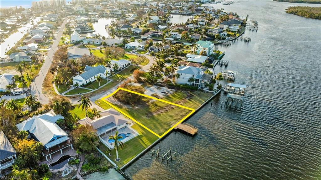 PREMIER BAYFRONT HOMESITE — BUILD YOUR DREAM HOME ON ESTERO BAY Paradise awaits on this rare, oversized Bayfront homesite offering direct Gulf access along the protected and prestigious Estero Bay Aquatic Preserve. Spanning 11,230 square feet with an impressive 95 feet of Bay frontage and 155 feet of depth, this exceptional property provides the ideal canvas to construct a new elevated two- or three-story Bayfront residence designed to capture sweeping water views and unforgettable sunsets. Enjoy front-row seating to nature’s daily show—dolphins and manatees gliding through the bay—right from your future private dock. Positioned on a quiet cul-de-sac and among the highest elevations on the island, this property is located within the highly desirable Holiday Heights neighborhood, offering both privacy and prestige. The existing structure is considered a teardown, and the property is being sold at lot value, allowing full creative freedom to design a custom home perfectly tailored to your lifestyle. Multiple builder introductions are available to assist in bringing your vision to life. Just a short stroll to deeded beach access, a nearby marina, and a grocery store, this one-of-a-kind bayfront parcel delivers the ultimate blend of boating, beach, and luxury island living. This is a rare opportunity to create a true coastal residence and be part of the ongoing Fort Myers Beach Renaissance.