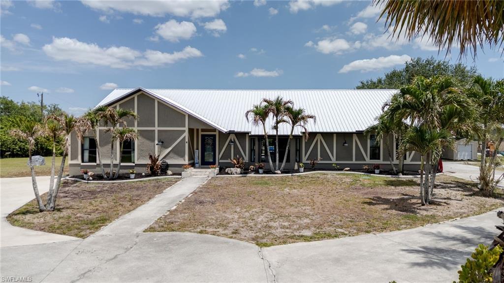 Experience the perfect blend of luxury, space, and entertainment on this fully fenced 1.25-acre agriculturally zoned property. The main residence has a modern farmhouse feeling and offers 4 bedrooms, 2 bathrooms, and just under 2,900 sq ft of living space, featuring luxurious travertine flooring throughout the main living areas and luxury vinyl in the primary suite. A show stopping kitchen update (2025) featuring quartz countertops with a stunning waterfall edge, sleek glass tile backsplash, and an eye-catching accent wall with a hooded range as a focal point, along with a charming coffee/hot chocolate bar with penny tile backsplash and a walk in pantry with stone-tiled bar area. Great space for entertaining as the kitchen opens up to 1200 ft of living area. Bright and spacious laundry room with a chic subway tile backsplash bringing style to a functional space. Major upgrades include a new metal roof (2023), tankless water heater (2026), and a newer AC unit. 

A standout feature is the 1500 square foot detached steel building/garage, offering additional living space, complete with a theater room, gaming area, and full gym, along with an oversized two-car garage.

Step outside to your private resort-style oasis featuring a huge 35 by 13 resurfaced PebbleTec pool, outdoor kitchen with Bull grill and refrigerator, plus a Sauna and Hot Spring spa—perfect for relaxing or entertaining. Slate pool table is included with the sale of home.

This one-of-a-kind property is tucked away for privacy yet close to it all—minutes from shopping and restaurants, 15 minutes from downtown Fort Myers and conveniently located to I-75. It is not in a flood zone and has hurricane impact windows and doors. It had very little damage during all hurricanes including Ian. Great property to have family and friends stay for safety during storms! Won't last as there is nothing like it to compare. Call today for private viewing.