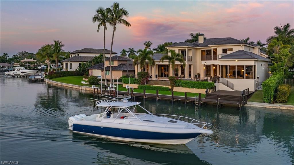 Wide western views and sparkling vistas of the bay are the focal point of this contemporary masterpiece in the heart of Park Shore. Completely reimagined, this 6 + bedroom offers impact doors and windows, Crestron automation, whole home generator, full wine cellar, an open floor plan and so much more.  Immediately upon entry you will be greeted by soaring ceilings, impressive 2 story glass windows, a stunning fireplace and handsome bar with ice maker and seating for all.  Entertaining is a breeze with a formal dining room with well-equipped catering passthrough to the gourmet kitchen which offers modern custom cabinetry, spacious island and Wolfe appliances. Spend evenings with the sliders open and enjoy the sunset from the covered lanai, open patio or by the outdoor fireplace taking in the sunset skies. The easy flowing floor plan provides a perfect primary suite and study on the first floor and a quick trip up the elevator your guests have 4 more bedrooms, bonus space and generous upstairs balcony. Ideally finished with high end, luxury finishes and a spacious boat dock with 20,000lb lift, this is truly paradise in Park Shore.