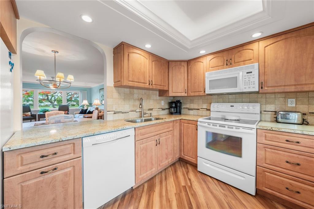 Wake up to sunshine, palm trees, and the carefree lifestyle that makes Seven Lakes one of Southwest Florida's most sought after 55+ communities. This beautifully maintained turnkey furnished second floor condominium offers 1,468 square feet of comfortable living space with two bedrooms, two updated bathrooms, and a versatile floor plan designed for both everyday living and hosting family and friends. The spacious primary suite features a walk in closet, while the guest bedroom includes a convenient Murphy bed and built in office area, creating the perfect combination of workspace and overnight accommodations. The enclosed Florida room expands the living area and offers tranquil golf course views along with a second Murphy bed for even more flexibility. Tile and laminate flooring throughout provide easy maintenance, and recent updates include a 2022 AC system and 2019 water heater. An exterior storage unit and assigned carport space complete the package. Beyond the front door, Seven Lakes offers a true resort lifestyle with bundled golf, tennis, pickleball, bocce, shuffleboard, multiple swimming pools, a fitness center, and an active calendar filled with social events. Enjoy the convenience of a gated community with a guard at the entrance while your condominium fees cover cable, internet, water, sewer, trash removal, lawn maintenance, and access to the exceptional amenities. Whether you're searching for a full time residence or a seasonal retreat, this move in ready home invites you to embrace the best of Southwest Florida living.