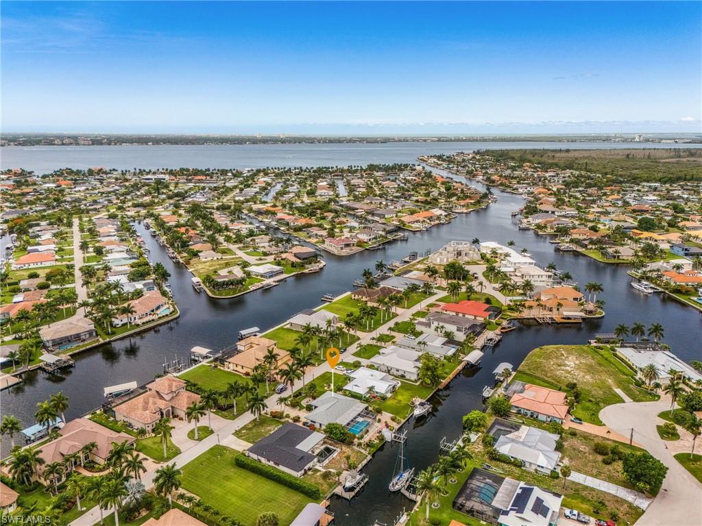 Set on the prestigious Sorrento Court Peninsula, this exceptional waterfront residence offers direct sailboat access to the Gulf with no bridges or locks and only minutes to open water. Capturing the essence of refined coastal living, the 3-bedroom, 3-bath home showcases a screened heated pool, expansive under-truss lanai that includes an outdoor kitchen, dining, and golf putting green, including stacked slider to combine indoor/outdoor entertaining. Bring your boat with fishing and water gear for your private concrete dock with a 13,000-pound boat lift and remote, plus electric and water at the dock.
Thoughtfully updated for comfort and peace of mind, the home features a 2021 roof, 2023 AC and ductwork, a full repipe completed in 2023, and a 2024 electric boatlift, no need to store your boat elsewhere. Additional amenities include lush landscaping, central vacuum, a screened under truss front porch, automatic sprinkler system, electric storm shutters and decorative shutters, a spacious 2-car garage with auto door, additional room under truss for locked storage perfect option for the fishing and water gear, and outdoor shower. Complete with a home warranty through America’s Preferred Home Warranty. Whether envisioned as a luxury vacation retreat, an income-producing waterfront escape, or a full-time residence, this turnkey property is ready for immediate enjoyment. Added to the investors’ appeal ~ established short term rental. Furnishings are negotiable and washer/dryer convey.
Ideally located near Publix, Yacht Club beach, Tarpon Point Marina, premier dining, boutique shopping, and vibrant nightlife, this residence pairs elite boating access with the finest conveniences of Cape Coral living.
Survey and Elevation Certificate on file.