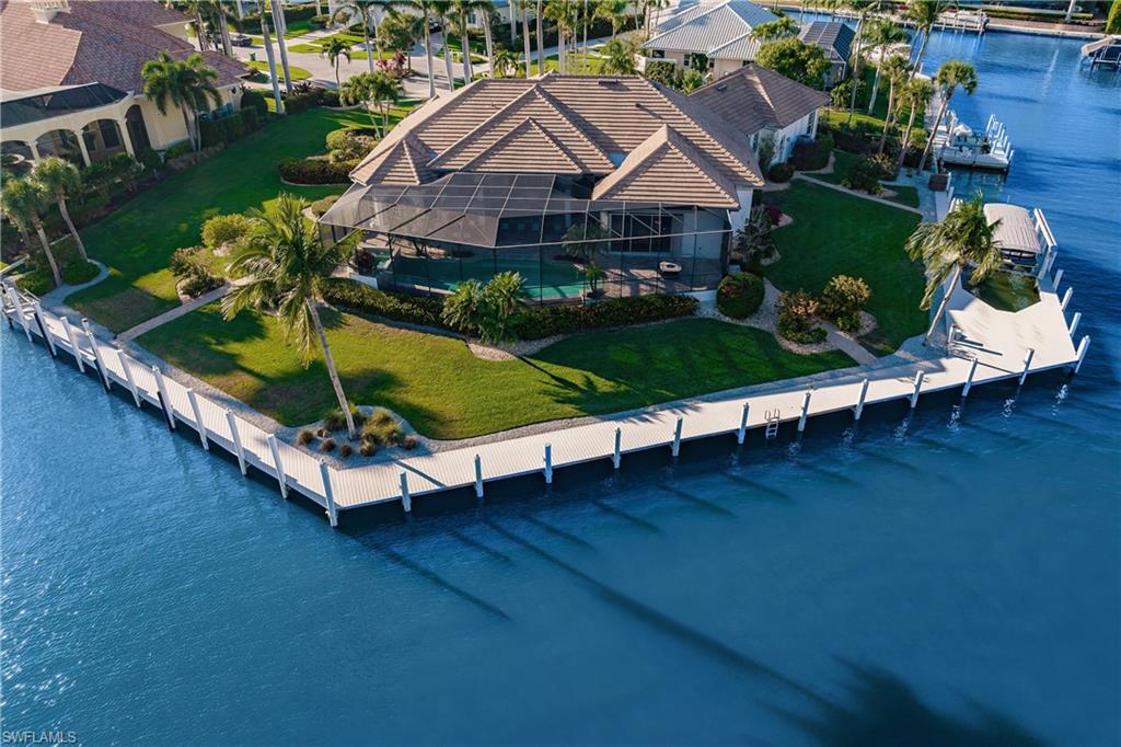 Now accepting backup offers. Truly a rare find - a "trophy" property - 1 of only 8 water direct tip lots on Marco Island w/Southern rear exposure on at least 0.7 ac & over 300' of waterfront - perfectly situated at the end of a peaceful cul-de-sac in the prestigious Estates with captivating water views to Roberts Bay from nearly every room in this meticulously-maintained custom estate. A deep-water boater's paradise, you can cruise to the Gulf of Mexico & pristine sugar-white beaches of the 10,000 Islands within minutes. Unwind in the spacious tropically-landscaped outdoor oasis in the sparkling infinity-edge pool and waterfall spa, complete with chef's kitchen and bar. Relax in the privacy of the owner’s suite sitting area or spa-like bathroom. The leisure room features a lighted tray ceiling, a gas fireplace, a wet bar, a built-in wine cooler, and an expansive entertainment system (w/ sonos enhancements) & speakers throughout. One of the few properties where you can dock your 100' boat, your 40' boat, & a jet ski & still enjoy unobstructed big water views.