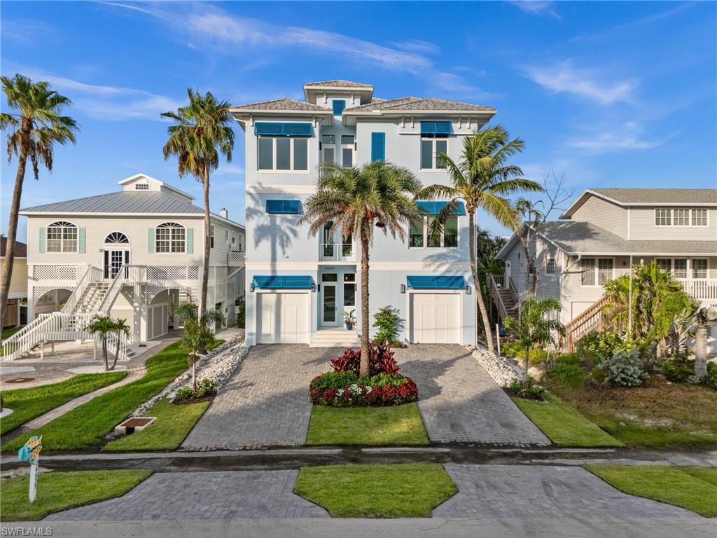 Coastal luxury meets laid-back island living in this beautifully designed 2019 multi-leveled home, perfectly positioned just steps from the quiet, uncrowded, white sands of Bonita Beach and its renowned sunsets.

Truly the best of both worlds.  A true gem for beach lovers and boaters alike; the property offers direct Gulf access in minutes from its private boat dock on the canal of Estero Bay while only footsteps to Beach via access 7.  

Built in 2019, a major standout feature is the first-floor elevation of 21 feet.  This elevated design not only provides exception protection from storm surge, but also enhances everyday living.  Unlike typical builds, where the pool is ground-level, this home offers a seamless indoor-outdoor flow, with a saltwater pool and spa on the Second Level -- a rare and valuable layout.

With 4 bedrooms plus a dedicated office or optional 5th bedroom, there is plenty of space for everyone to sleep, relax and unwind.

The second-floor lanai offers an exceptional indoor-outdoor experience for you and your guests.  Complete with a saltwater pool and spa and retractable hurricane screens, it is perfect for year-round entertaining or quiet evenings at home.

Inside, enjoy 12-foot ceilings, shiplap accented walls, and a gas fireplace that adds depth and character.  The chef's kitchen is outfitted with premium WOLF, Subzero, and Bosch appliances, a spacious 5-seat island, walk-in butlers pantry and 3 laundry zones for ultimate convenience.  This home is being offered turnkey furnished, including stylish pieces by NORRIS Furniture.  Everything you need to move right in or begin generating rental income, including, all bedding, window treatments, linens, dishes, silverware, artwork, and decorator accessories.

An elevator provides easy access to all levels.  The third-floor primary suite feels like a private retreat offering serene Bay Views from the balcony.  Featuring a tray ceiling, spa-inspired bathroom with dual vanities and shiplap walls.  The third floor offers three additional guest suites that include their own private bathroom; along with a centralized wet bar, this makes this level perfect for relaxing.  A rare 4+ garage with both front and rear access offers the ease of pulling in and out from either Hickory Blvd., or Bay Road,...ideal for cars, golf carts, or boat storage.  

Whether you are looking for a full-time island residence or a high-grossing vacation rental, this exceptional property delivers on both lifestyle and peace of mind and even includes a transferable flood insurance policy.