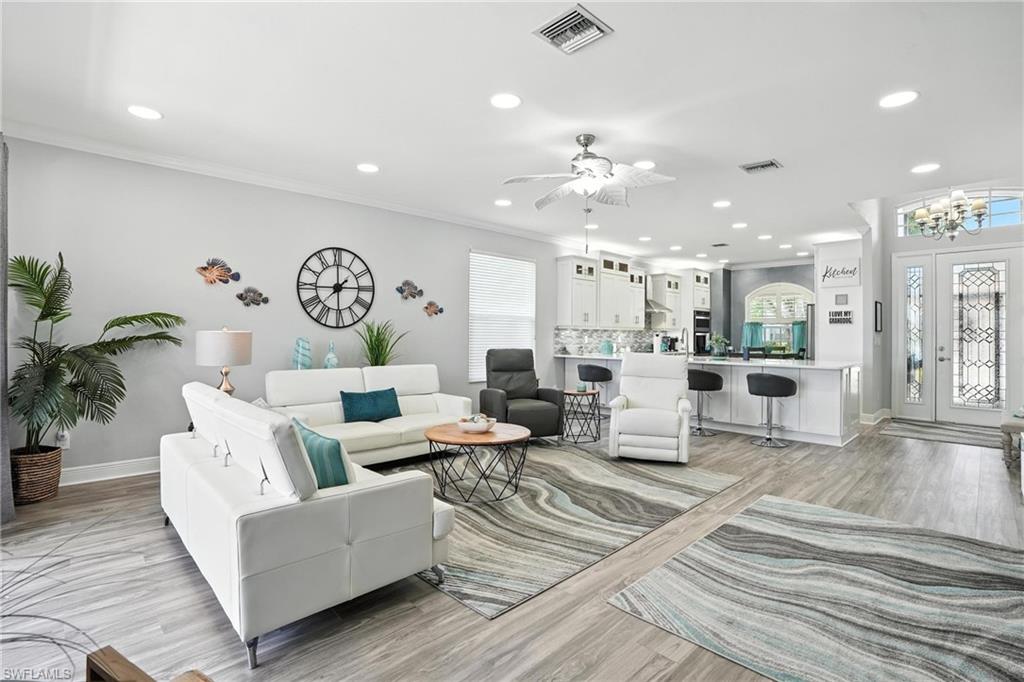 Sophistication Meets Serenity Meets Value in This Stunning SilverLakes Residence **All Big Ticket Items Taken Care Of For You.** Welcome to refined Florida living in the prestigious, gated community of SilverLakes in The Gateway. This meticulously maintained home blends timeless elegance with modern updates, offering three spacious bedrooms and 2 luxurious baths in one of the community’s most sought-after floorplans. From the moment you step through the vaulted entryway, you’ll be captivated by the home’s flowing open-concept design. The expansive great room, kitchen, and dining area provide the perfect setting for both relaxed everyday living and elegant entertaining. The completely remodeled gourmet kitchen impresses with crisp white cabinetry, stainless steel appliances, a massive island with bar seating, breakfast nook, and ample pantry—blending function and style with ease. Throughout the home, sleek plank flooring adds an air of luxury, while the trim and finishes sparkle. The primary suite is a private retreat, featuring well-lit roominess, dual vanities, a spa-like step-in shower, and wonderful walk in closet. Natural light floods every room, accentuating the graceful finishes and thoughtful details such as crown molding, designer trim, upgraded counters and appliances, and the luxurious view over your pool and the lake. Step outside to your own piece of Florida—overlooking the tranquil lake and take a dip on your own pool covered by a screened lanai offers- the perfect place to relax or entertain in privacy. This exceptional residence is built with both beauty and resilience in mind.