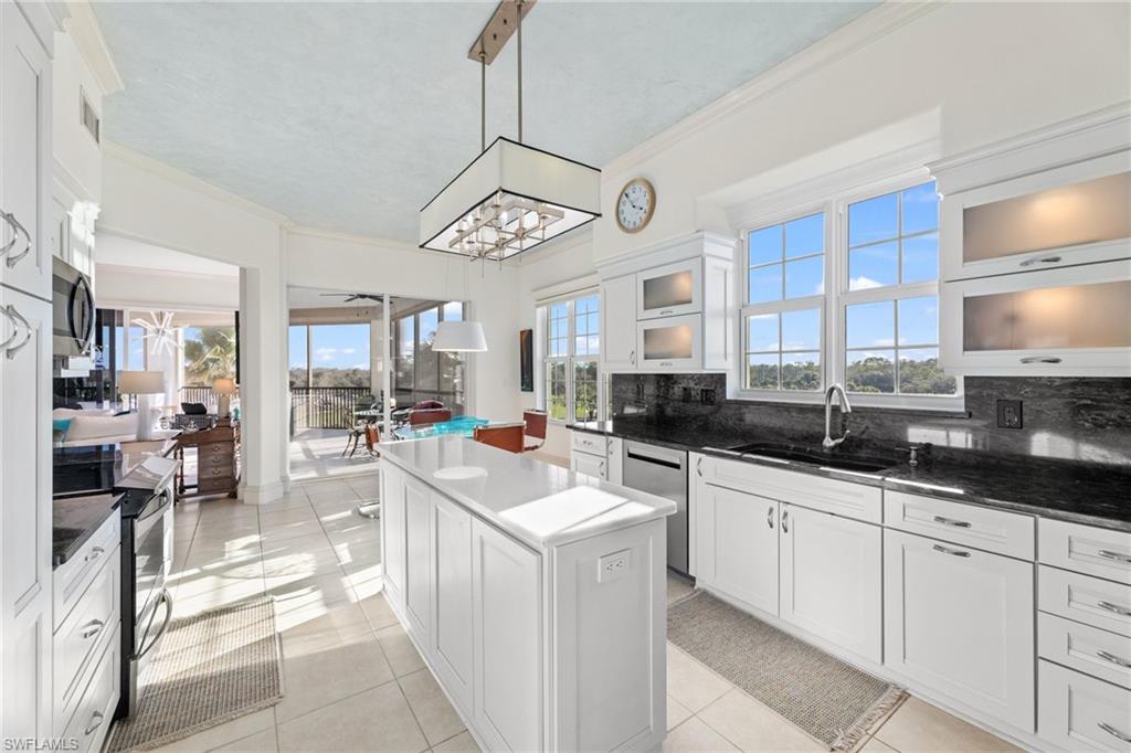 As close to living in a luxurious tree house as you can get! Nestled in the highly desirable Vista Pointe in The Vineyards, this stunning end-unit condominium offers breathtaking bird’s eye views of the newly renovated north golf course and multiple lakes  with an abundance of natural light from its southern exposure and multiple windows. Featuring 3 bedrooms plus a den and 3 full bathrooms, this spacious home features a primary bedroom suite with a beautiful spa like bath with oversized shower and separate bath. A thoughtfully designed open layout. The open kitchen is a chef’s dream, featuring a center island, stainless steel appliances, and generous sunlight streaming in through expansive windows. Elegant tray ceilings, crown molding, plantation shutters, and a combination of tile and designer carpet flooring elevate the interior’s charm. The wraparound screened lanai provides a peaceful retreat, perfect for entertaining or unwinding with serene golf course and water views. Additional highlights include 2 deeded under-building parking spaces, electric hurricane shutters for peace of mind  and abundant storage including a shared storage area outside the unit and a private locker in the garage. Residents enjoy an effortless, maintenance-free lifestyle in a community designed for relaxation and recreation. The resort-style pool with cascading waterfalls is the perfect place to soak up the Florida sunshine, while the clubhouse offers a caterer’s kitchen, social room, fitness room, and picnic area with several gas grills for social gatherings. There is also a lobby remodel underway to update the entrance of the 560 building. Vista Pointe is located just steps from the prestigious Vineyards Country Club, residents have the option to join an exclusive private membership featuring 36 holes of championship golf, 12 Har-Tru tennis courts, pickleball, bocce, and a brand-new wellness and spa facility with a state-of-the-art fitness center, café, halotherapy salt room, massage and salon services, and a saltwater lap pool. All of this is nestled within a secure, gated community, offering easy access to premier shopping, dining, and entertainment. Whether seeking an active lifestyle or a peaceful retreat, this Vista Pointe residence is the perfect place to call home!