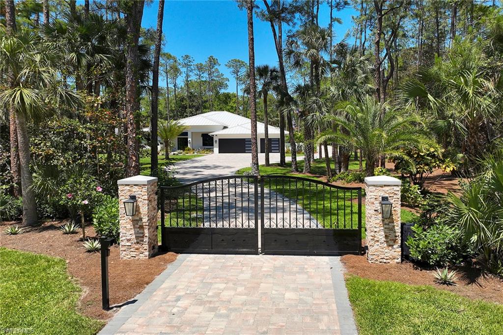 Look no further than this custom, nearly new, secluded 2.27-acre estate in exclusive Logan Woods. Completed in 2024, the five-bedroom plus study, five-full and one-half-bath great room home with three-car attached garage leaves nothing to be desired. Behind the home, a winding brick paver driveway leads to an additional detached climate-controlled three-car garage, ideal for additional automobiles, workshop or storage. The custom kitchen with an upscale mix of white quartz and quartzite countertops and high-end JennAir appliance package flows to the expansive, covered lanai with cypress wood ceiling ideal for entertaining family and friends. The tranquil private outdoor living area continues with an oversized heated pool and raised spa with an additional sun shelf and lap lane, outdoor kitchen with XO gas grill, all screened-in with unobstructed picture window screens. Additional features include a whole home R/O system and Generac generator, automated front entry gate, hurricane-impact windows and doors throughout and a convenient pool bath. A world of luxury awaits you in Logan Woods, close to all Naples has to offer, yet allowing for a private, secluded lifestyle.